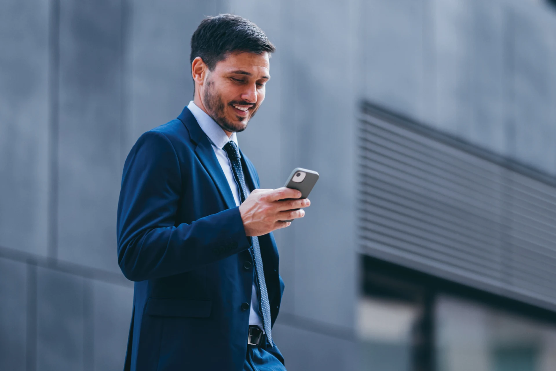 Professional checking smartphone outside office for TestMu AI quality engineering