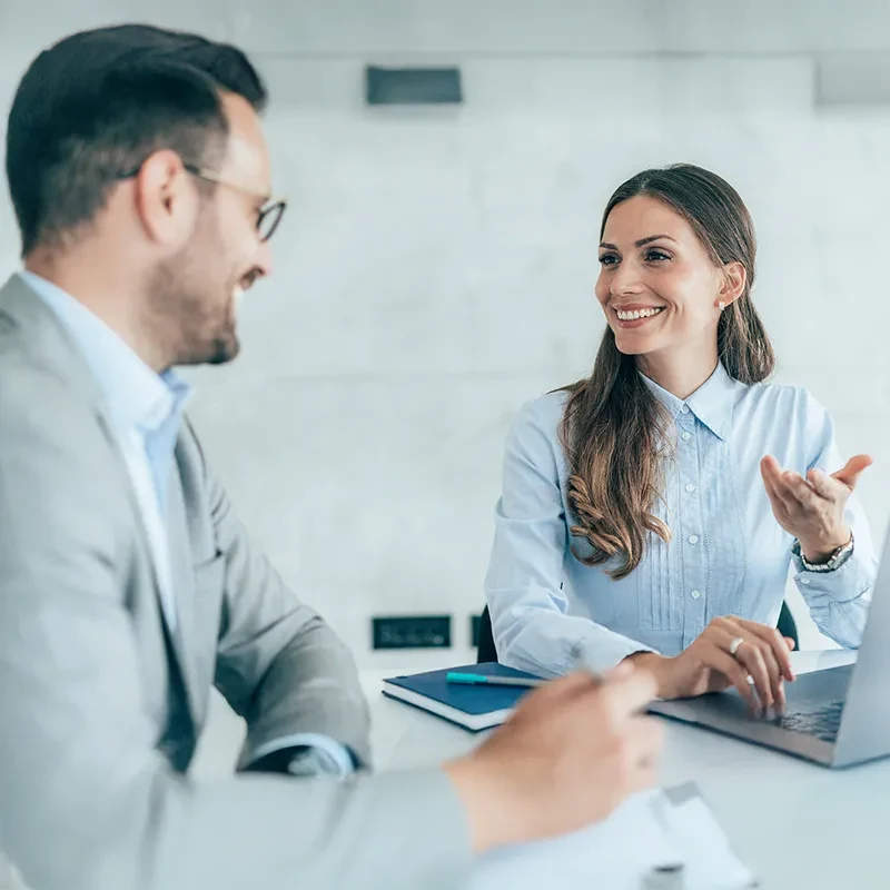 Two professionals discussing financial technology at a meeting table