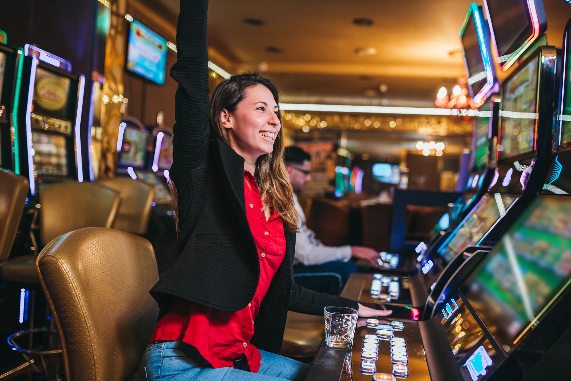 Player celebrating a win at a slot machine in a casino setting