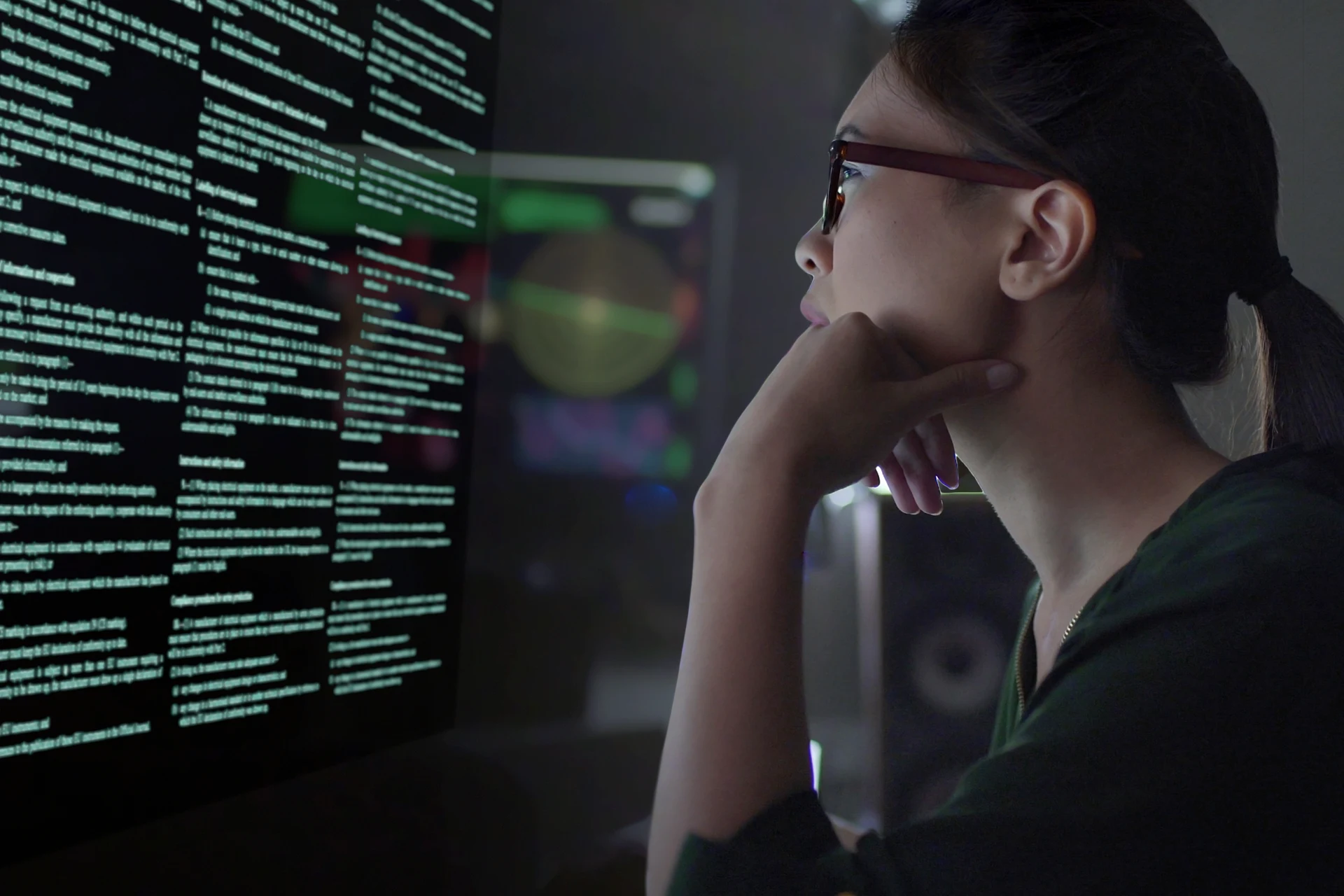 Professional analyzing data on a screen in a technology setting.