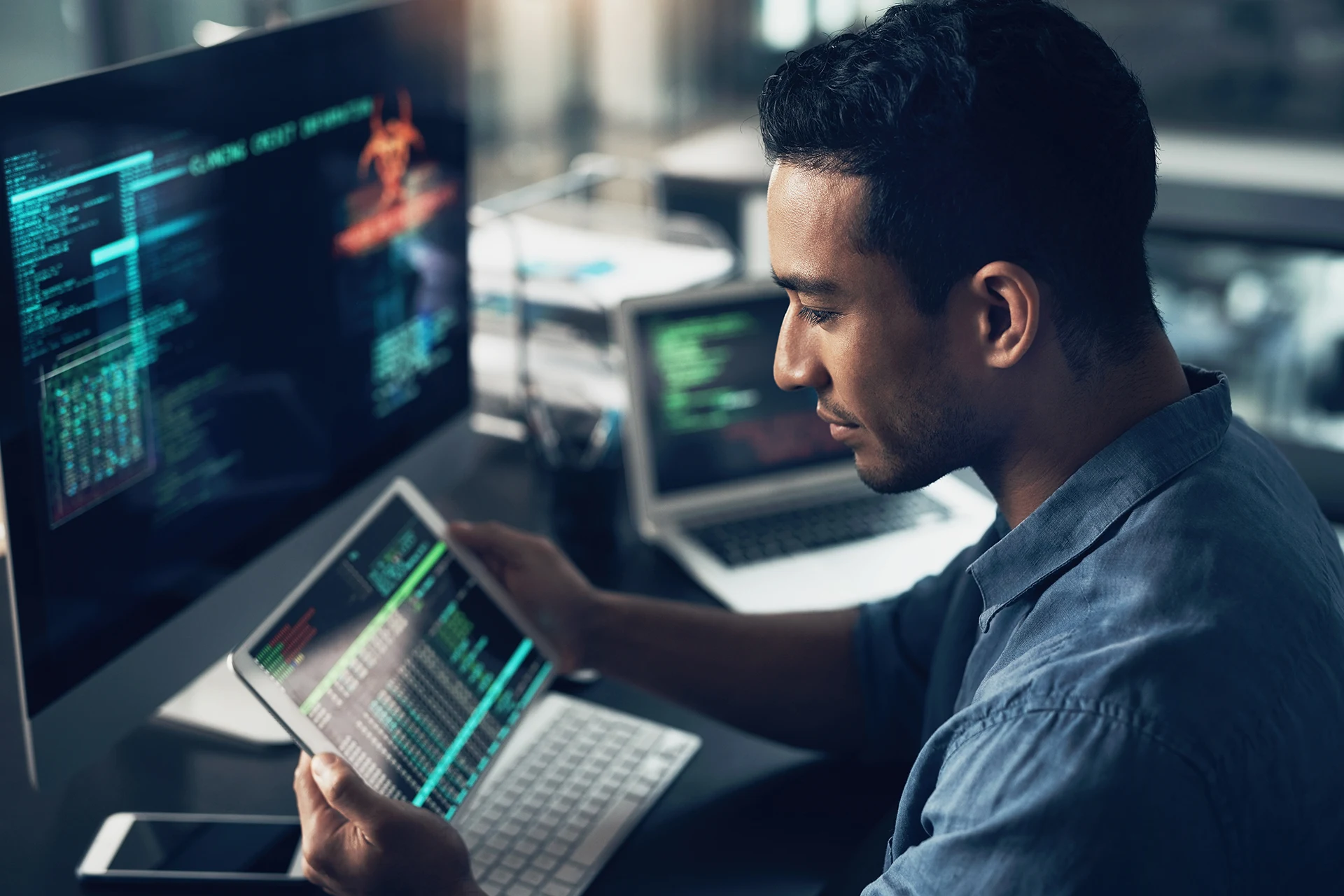 Professional analyzing data on a tablet while reviewing cybersecurity metrics.