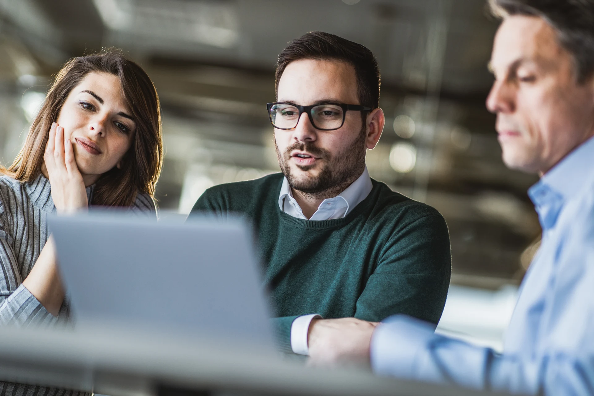 Professionals discussing digital operations while using a laptop