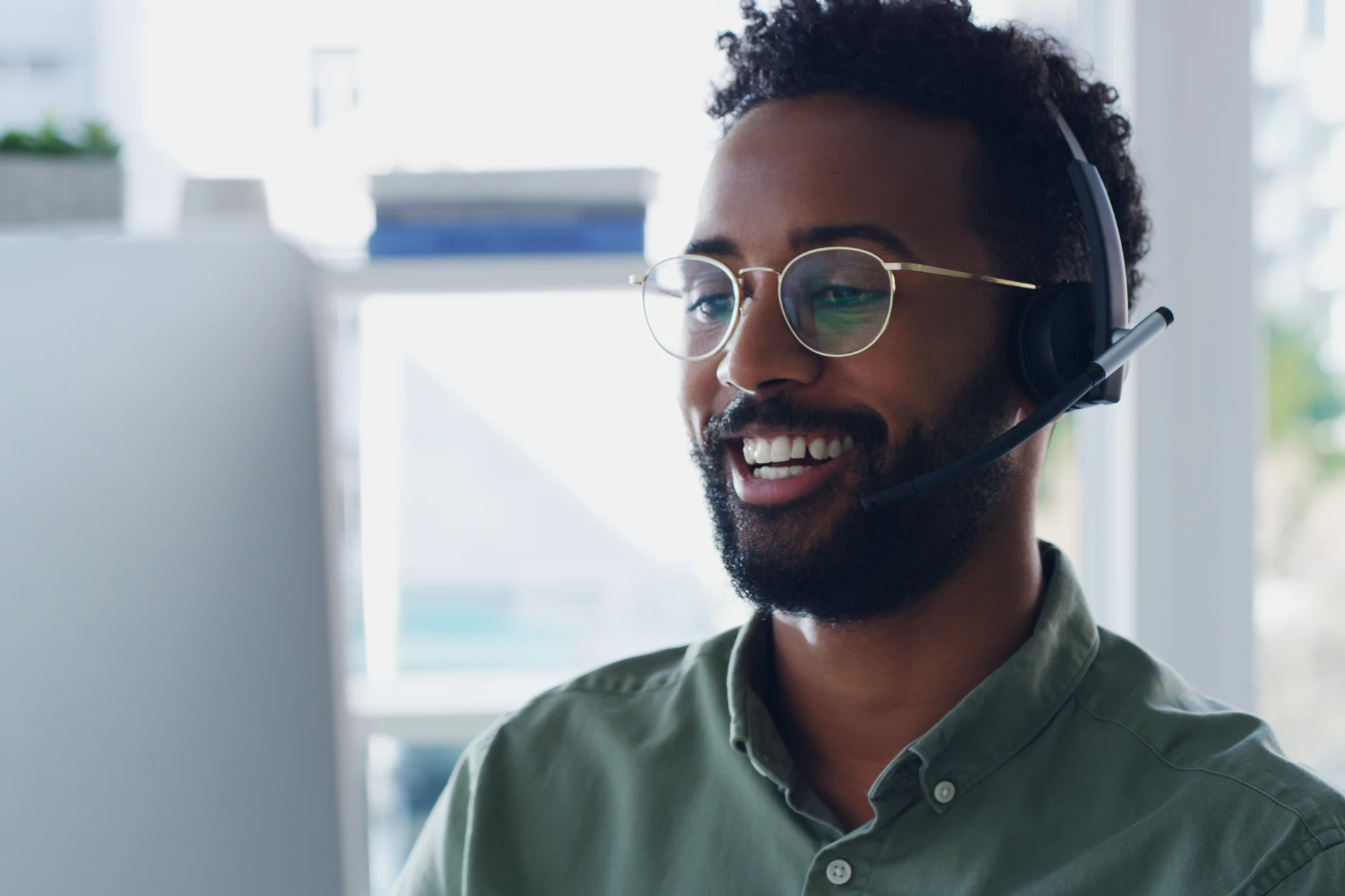 Individual using a headset while interacting with a computer.
