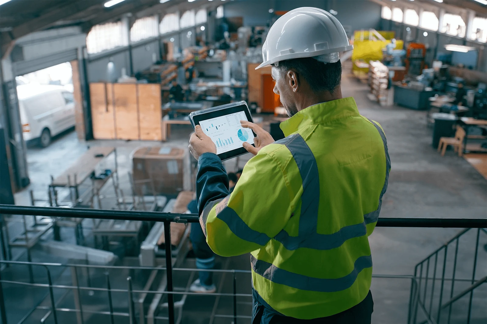 Worker analyzing supply chain data on a tablet in a warehouse