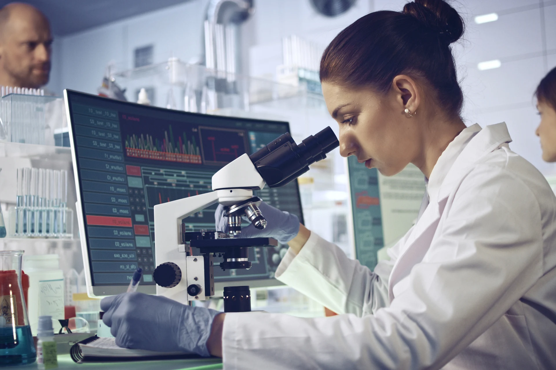 Scientist using a microscope in a laboratory setting for research.