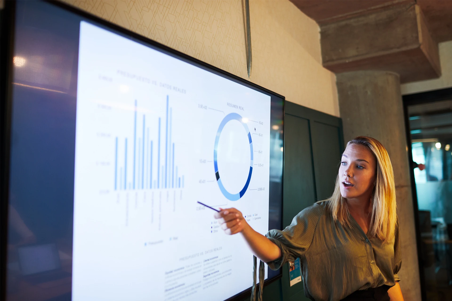 Presenter explaining data trends on screen during a business meeting
