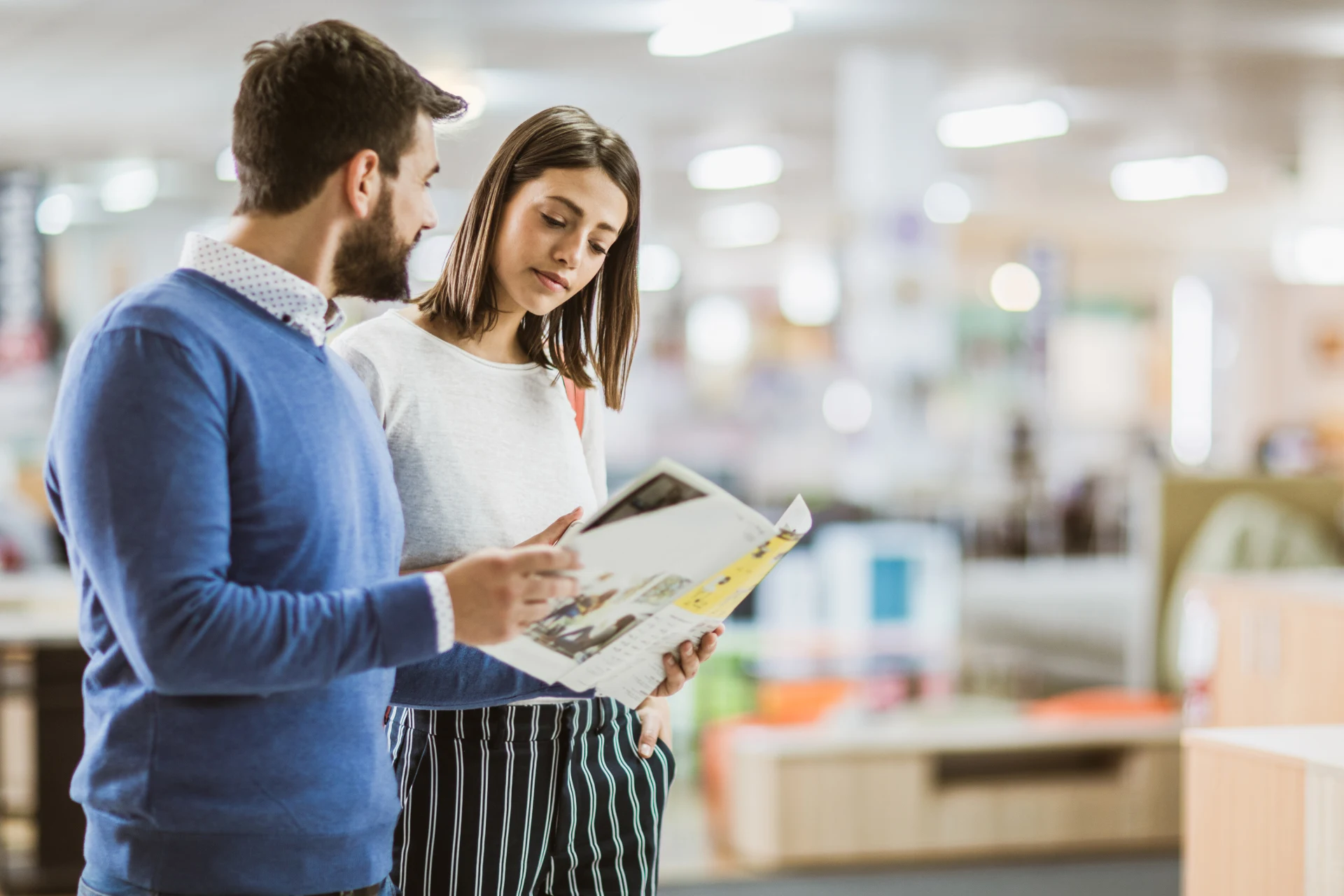 Two individuals reviewing a magazine in a retail environment