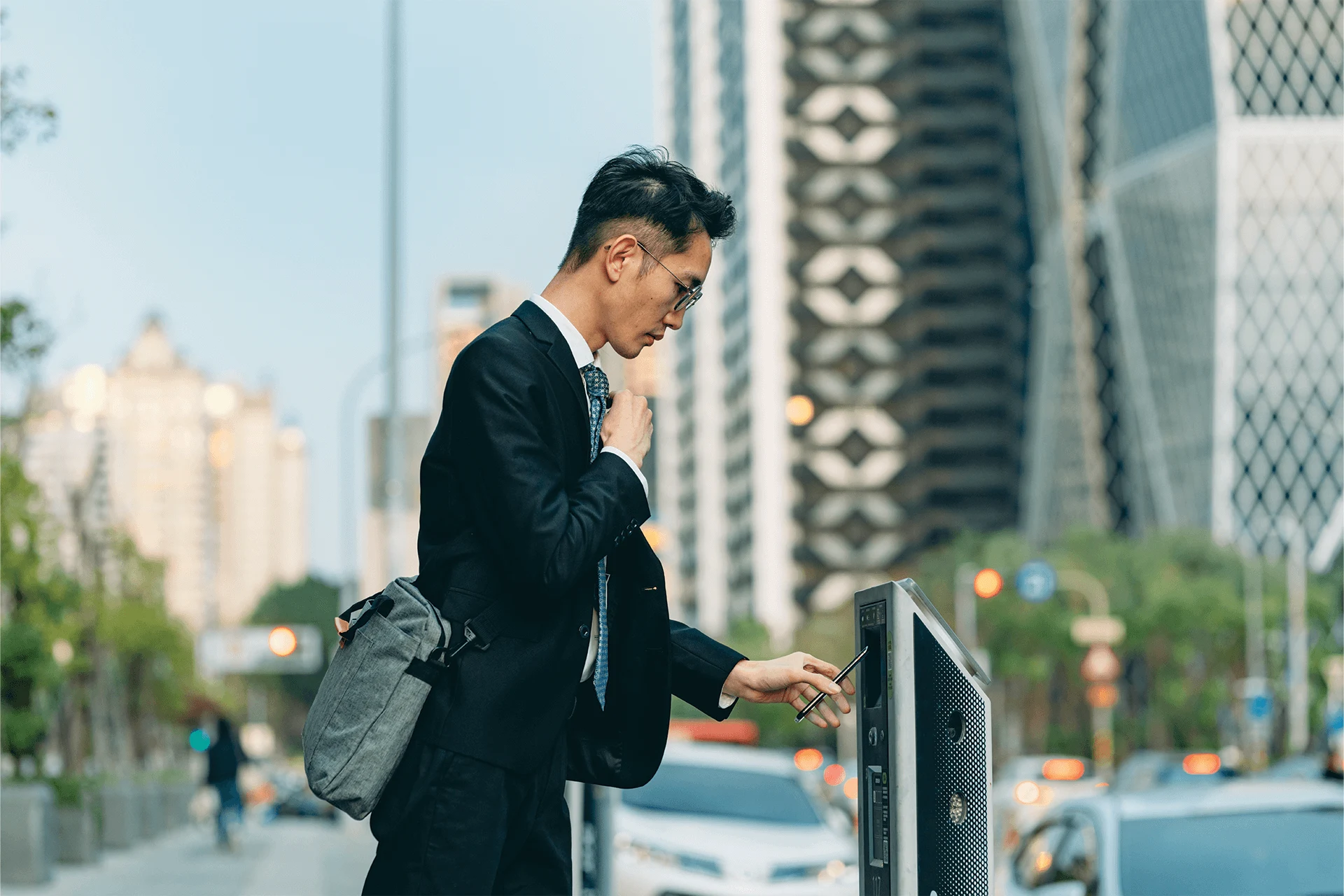 Businessman interacting with a smart city kiosk in an urban environment.