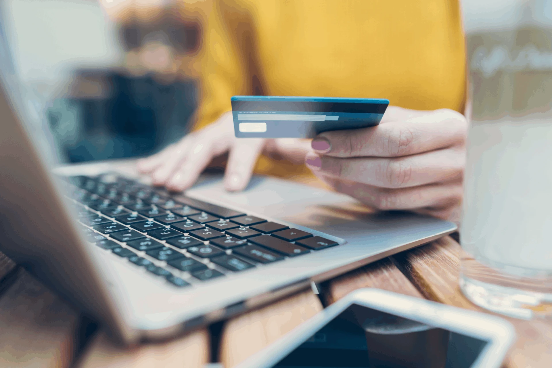 Person using a laptop and holding a credit card to make a payment
