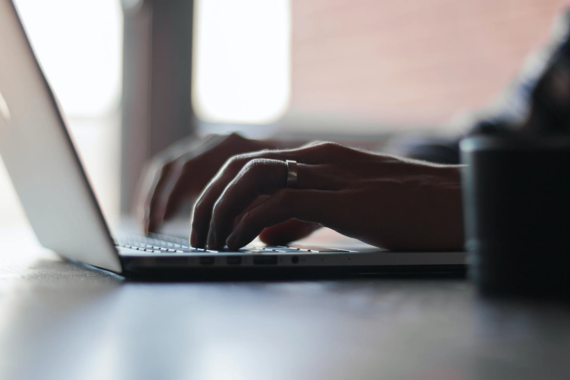 Hands typing on a laptop in a workspace highlighting AI solutions against fraud