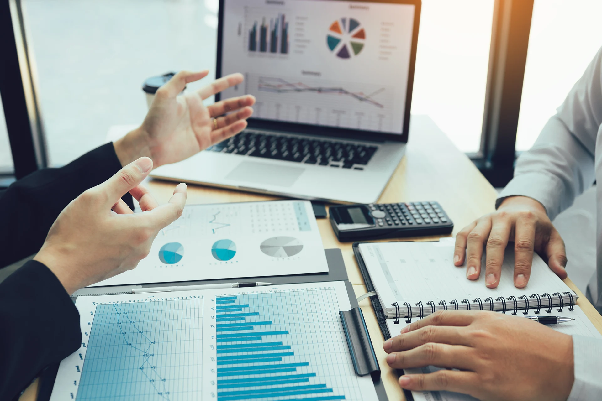 Two professionals discussing data insights with charts and graphs.