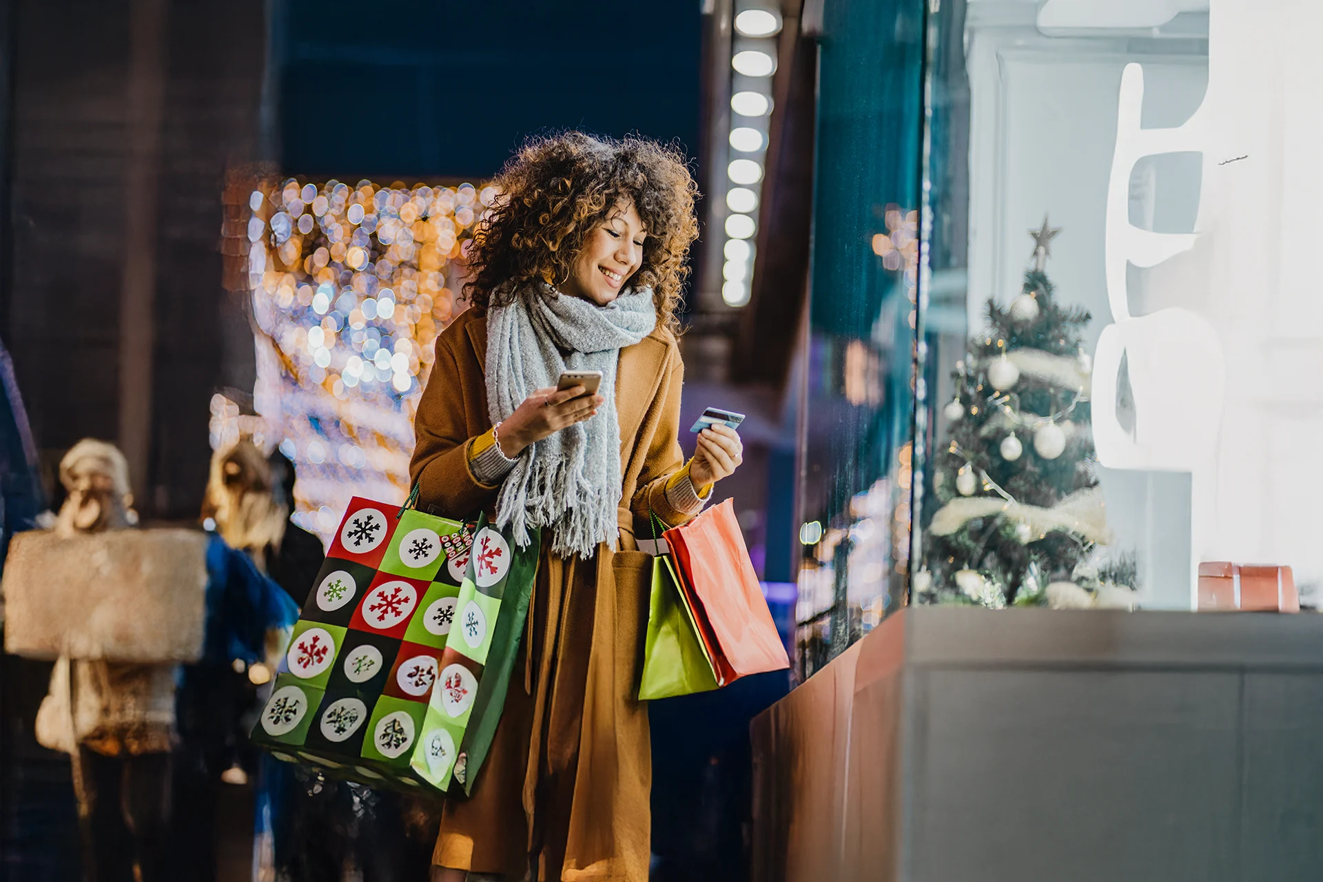 Woman using smartphone and holding card, symbolizing digital payments and consumer services image