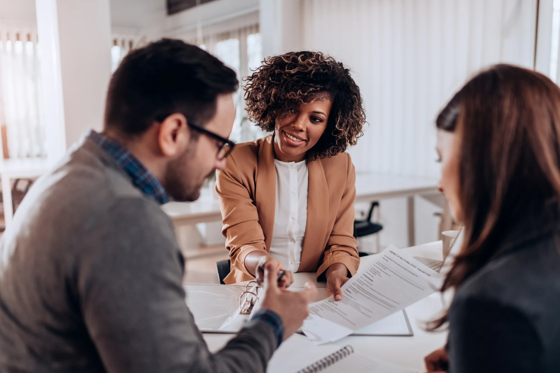 Professionals discussing documents during a meeting at a modern office.