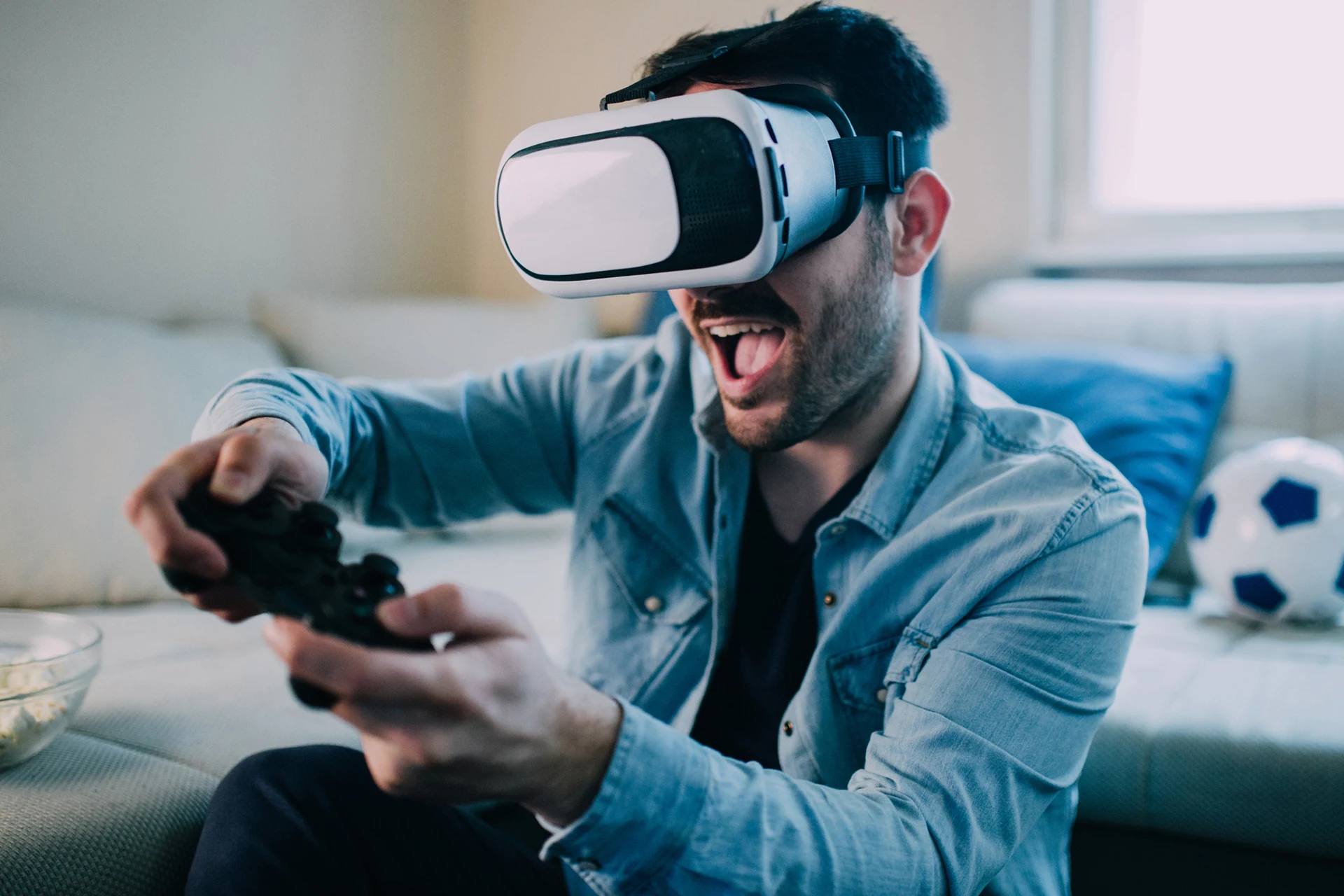 Person using a VR headset and game controller while seated indoors