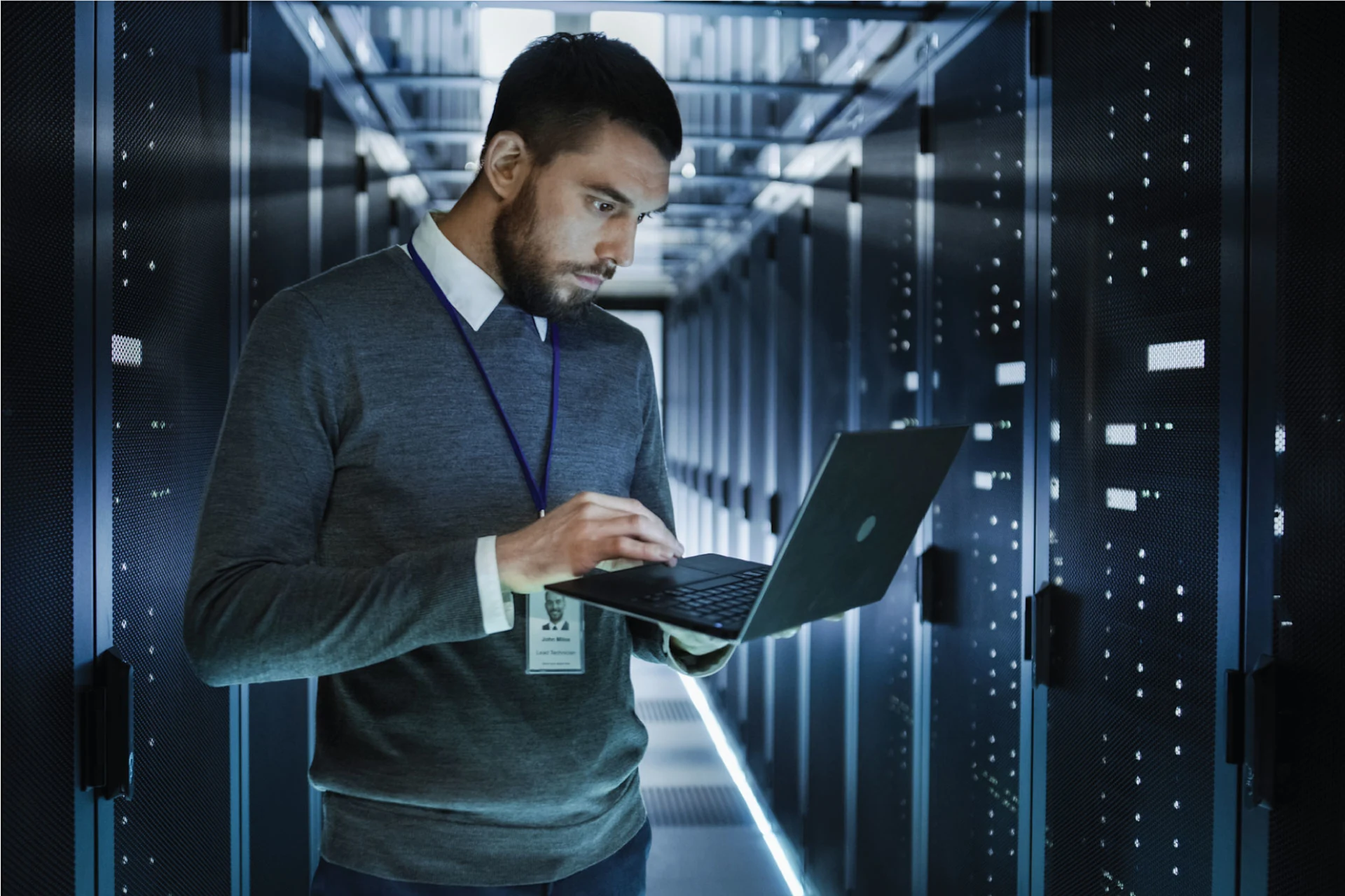 Professional using a laptop in a data center for IT transformation