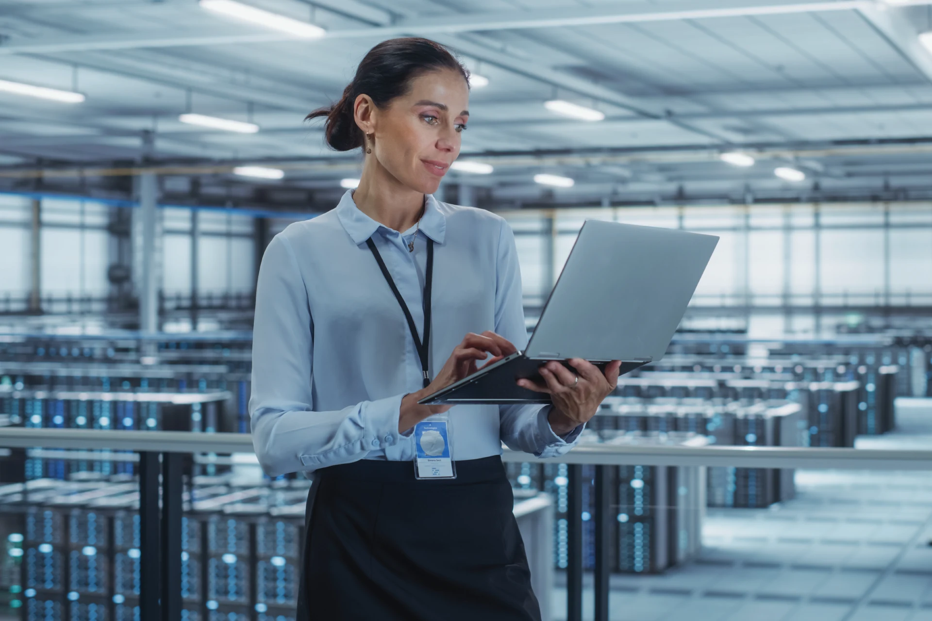 Professional working on laptop in data center during modernization efforts.