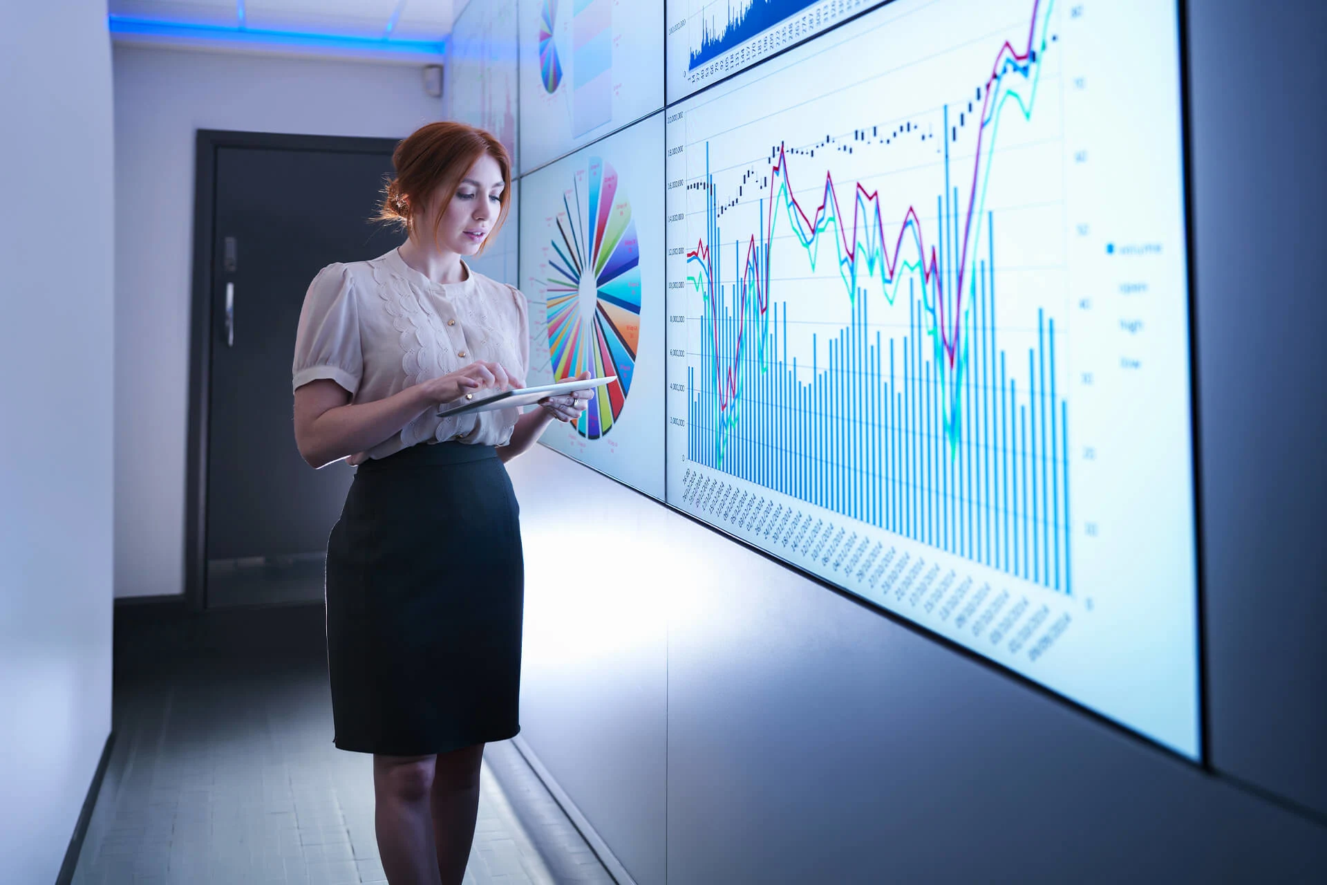 Professional analyzing data charts on large screens in a modern office