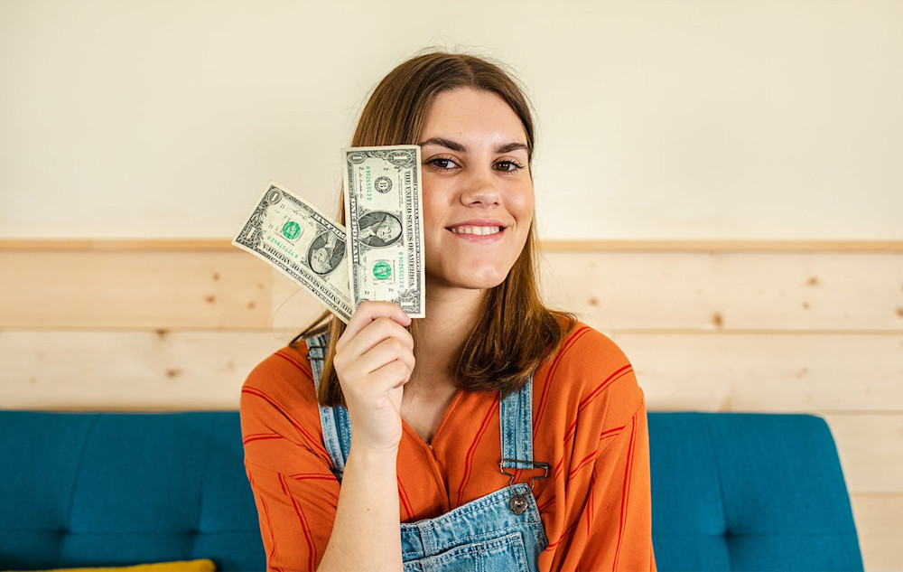Teenage girl holding up money