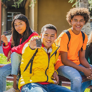 3 teens smiling with a Step Card