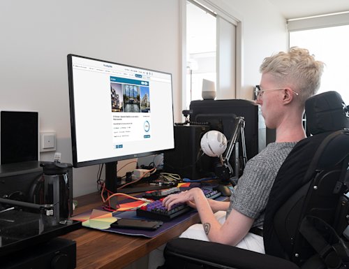 person in a manual chair using a computer