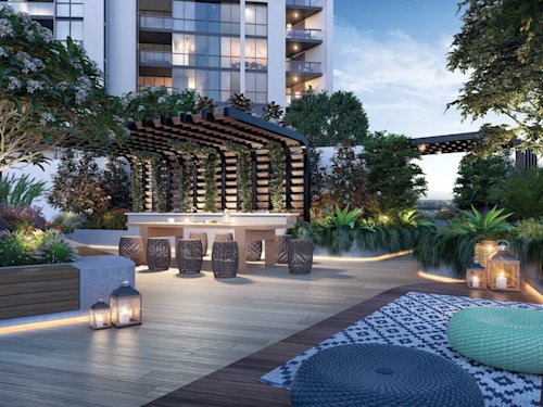 Image of apartment building exterior, decking area with lots of trees and outdoor seating