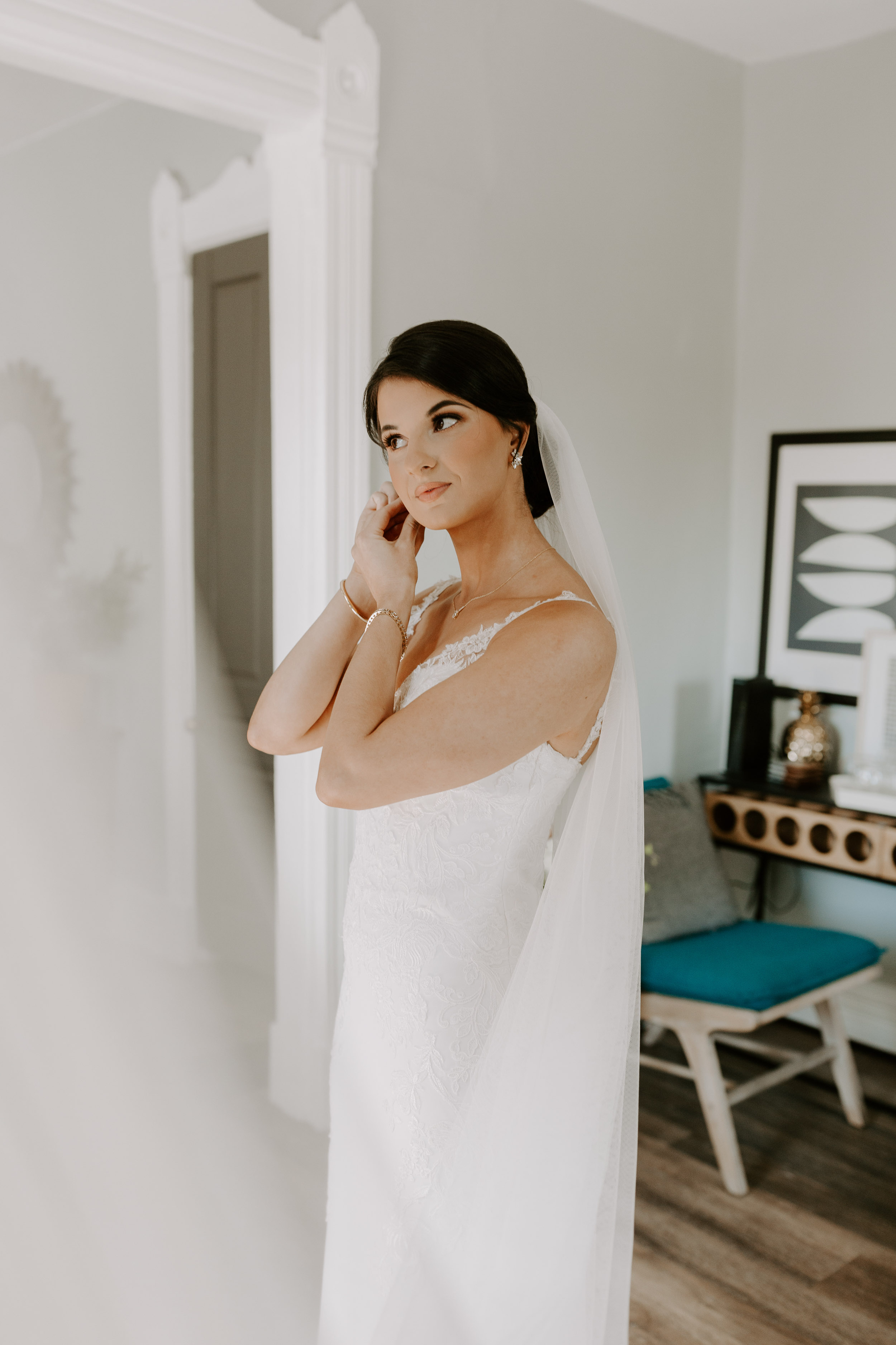 Getting ready for wedding photos | Bride putting on earrings