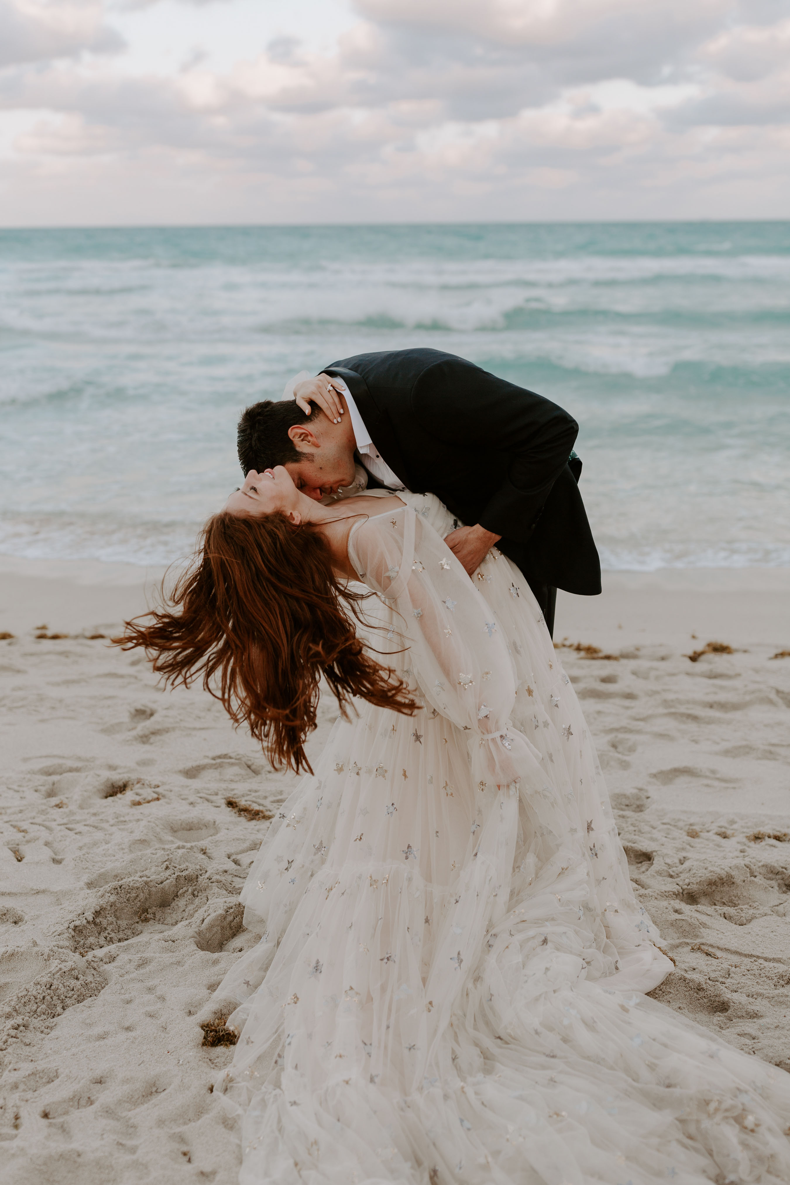 Dramatic poses for wedding photos on the beach