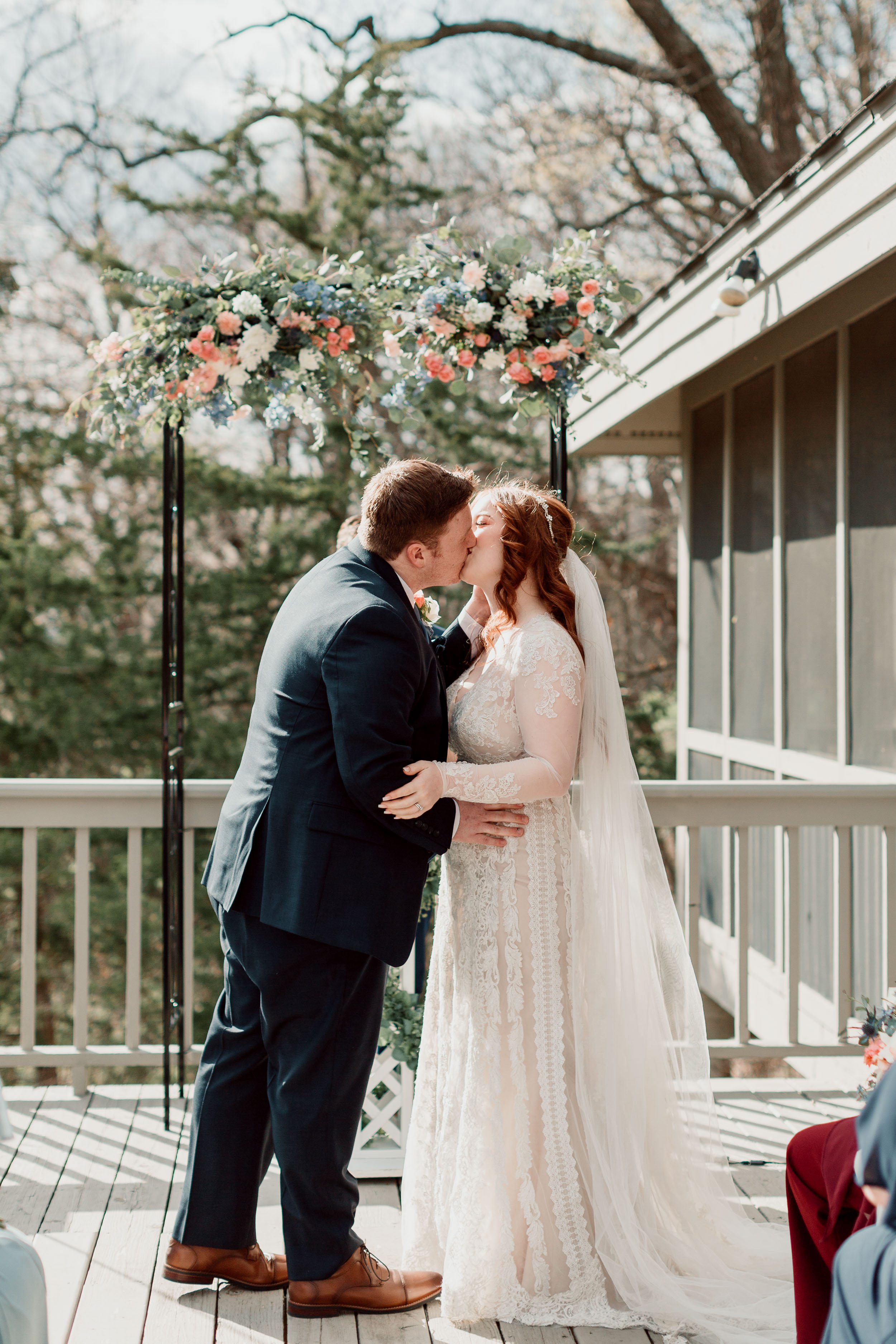First kiss under floral wedding arch