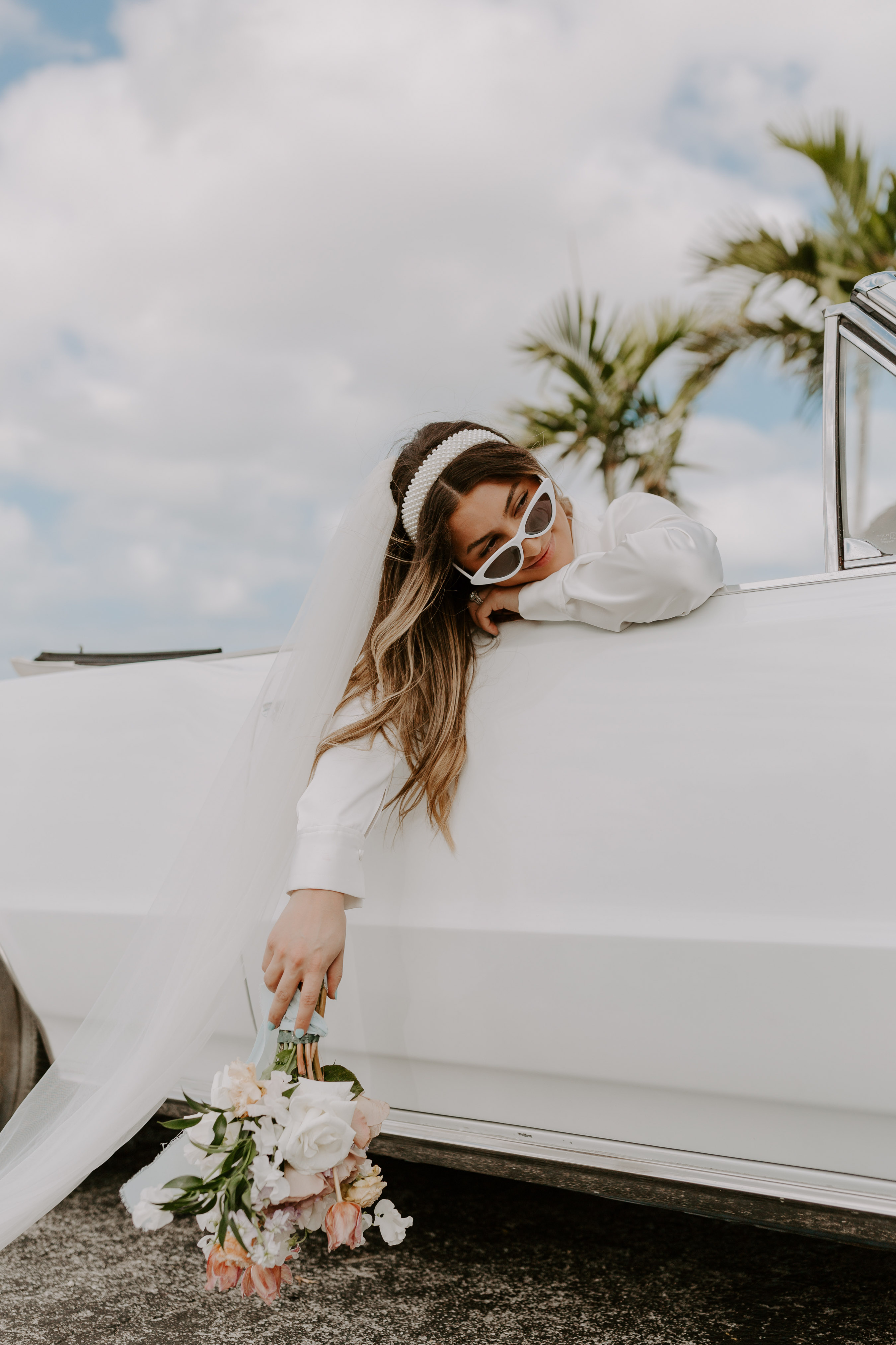 Bride with bouquet in vintage white car