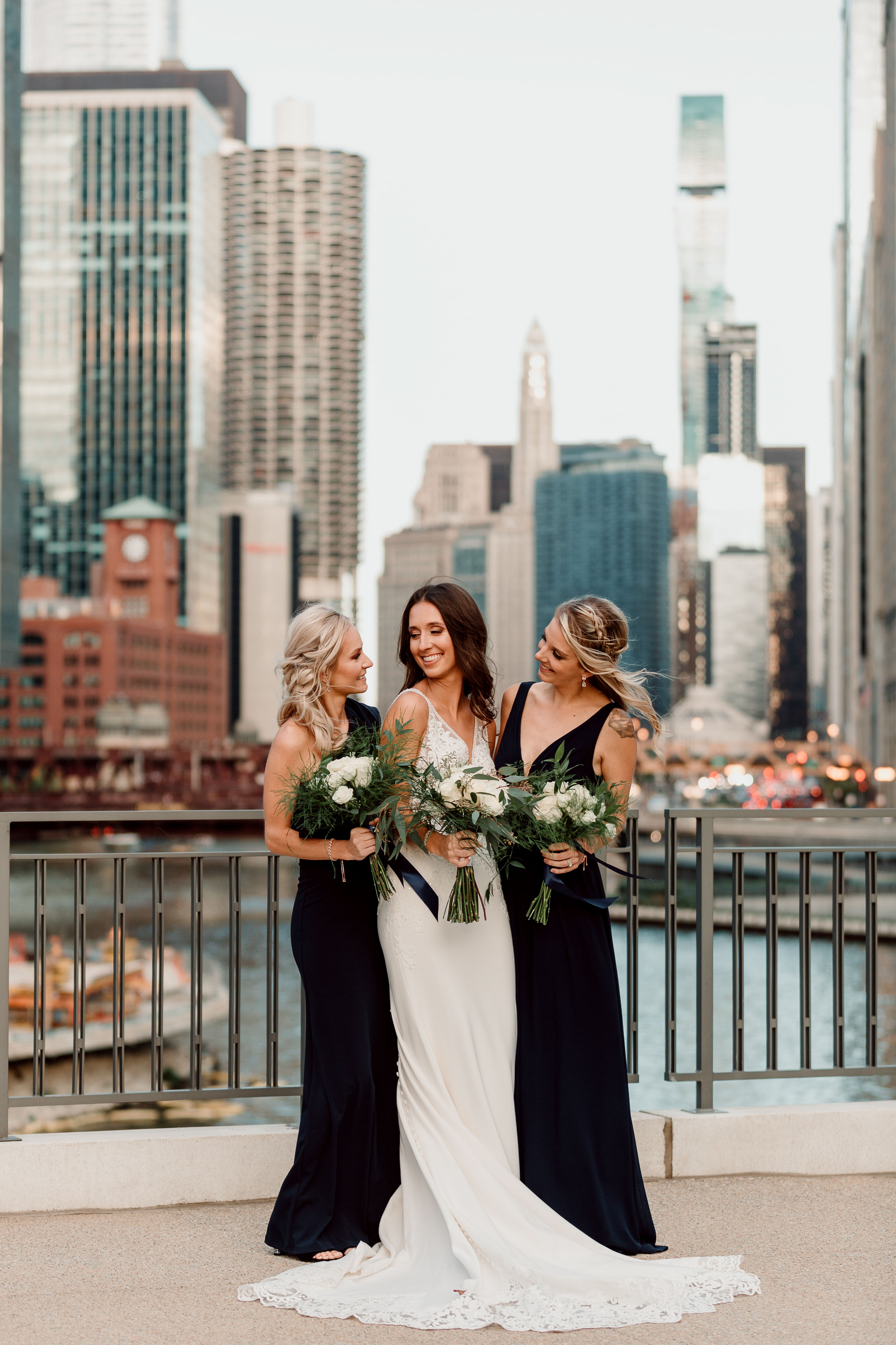 bride with bridesmaids in front of Chicago River and skyline