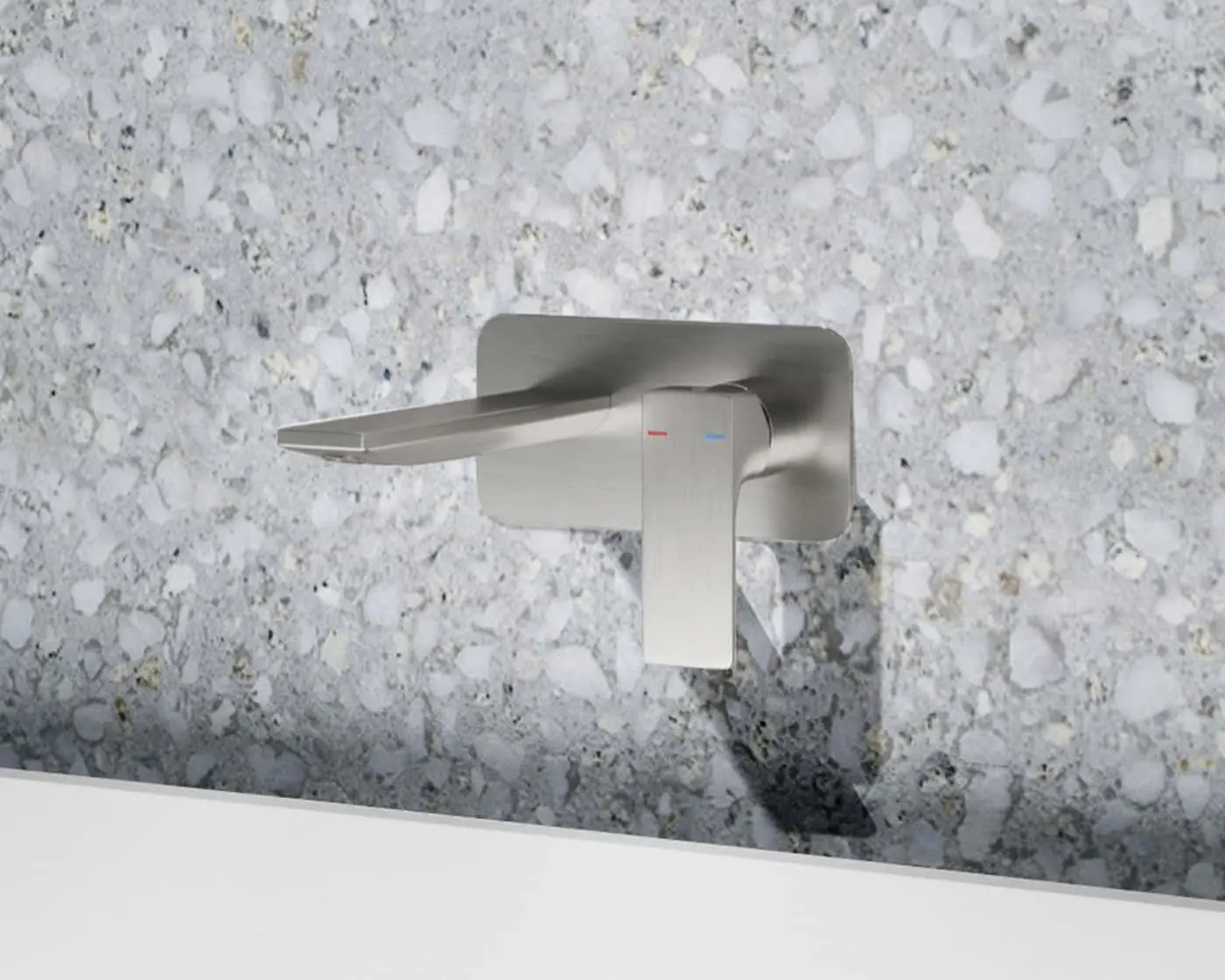 Modern brushed stainless steel wall-mounted faucet with flat spout against a speckled gray stone or terrazzo background.