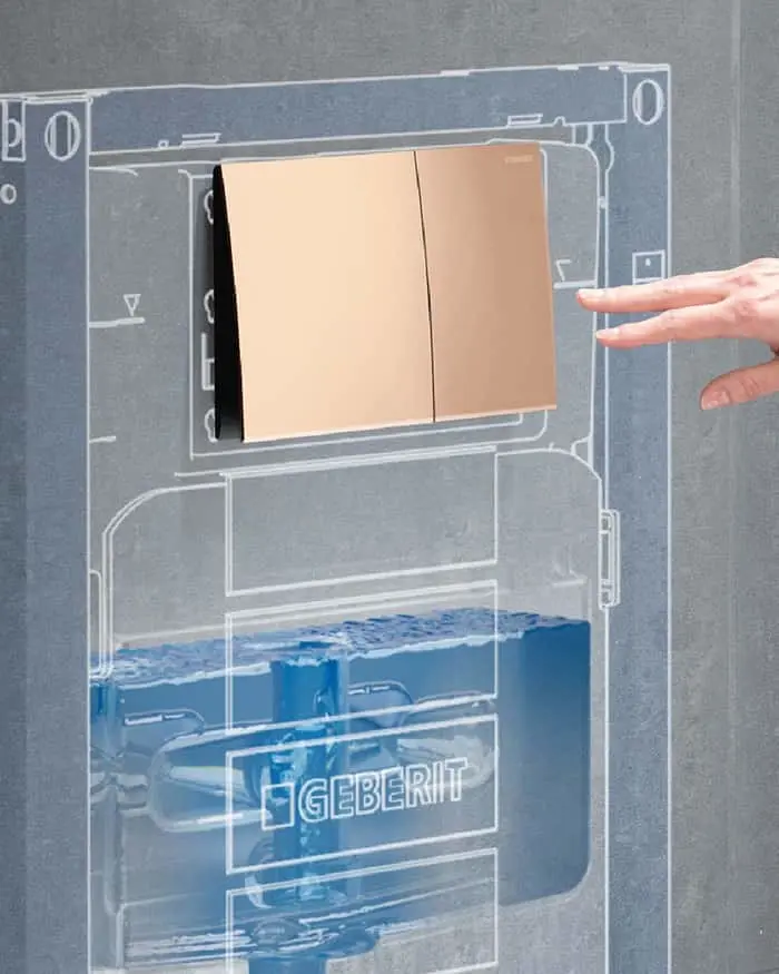 Gold dual flush plate mounted on wall with Geberit in-wall tank system visible through cutaway diagram.