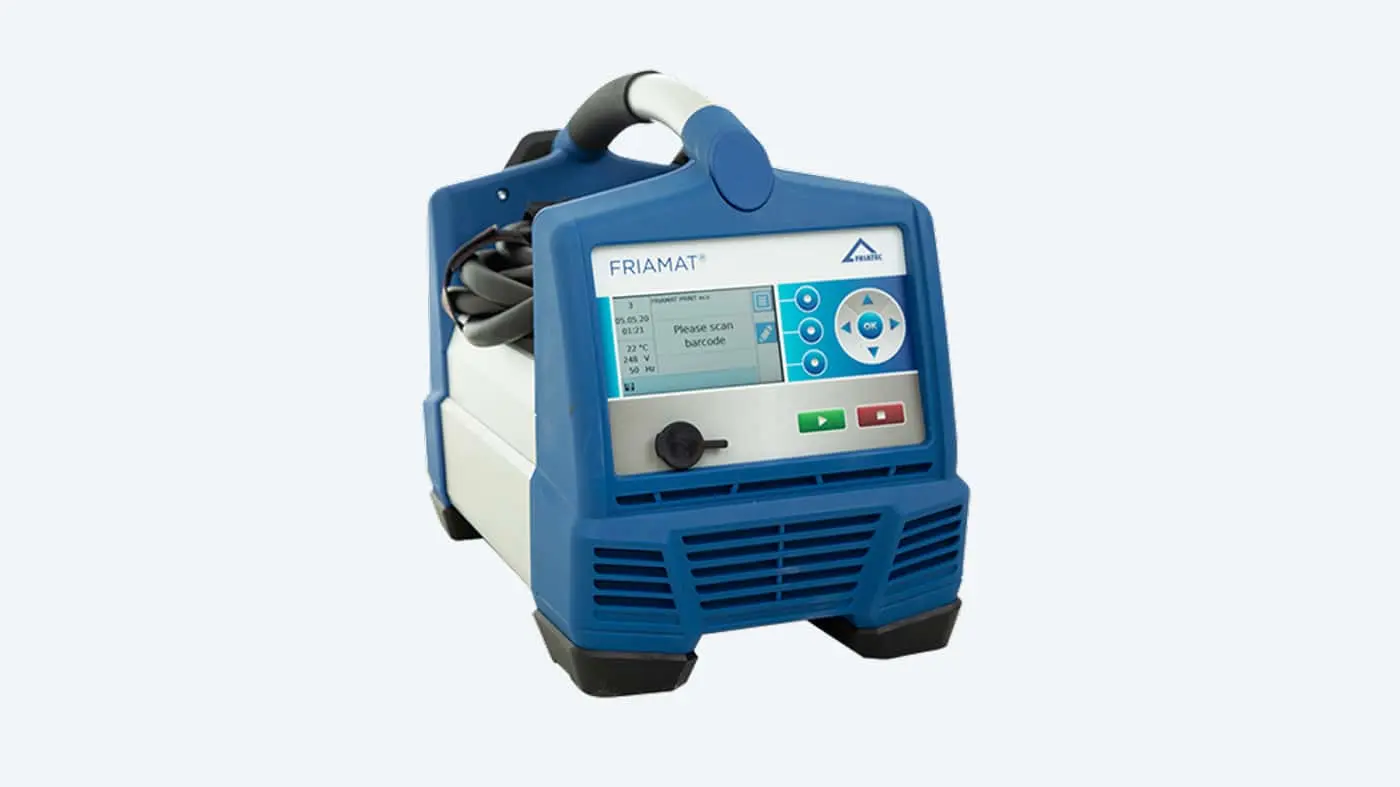 Blue FRIAMAT portable electronic device with digital display screen, control buttons, and handle for field operations.