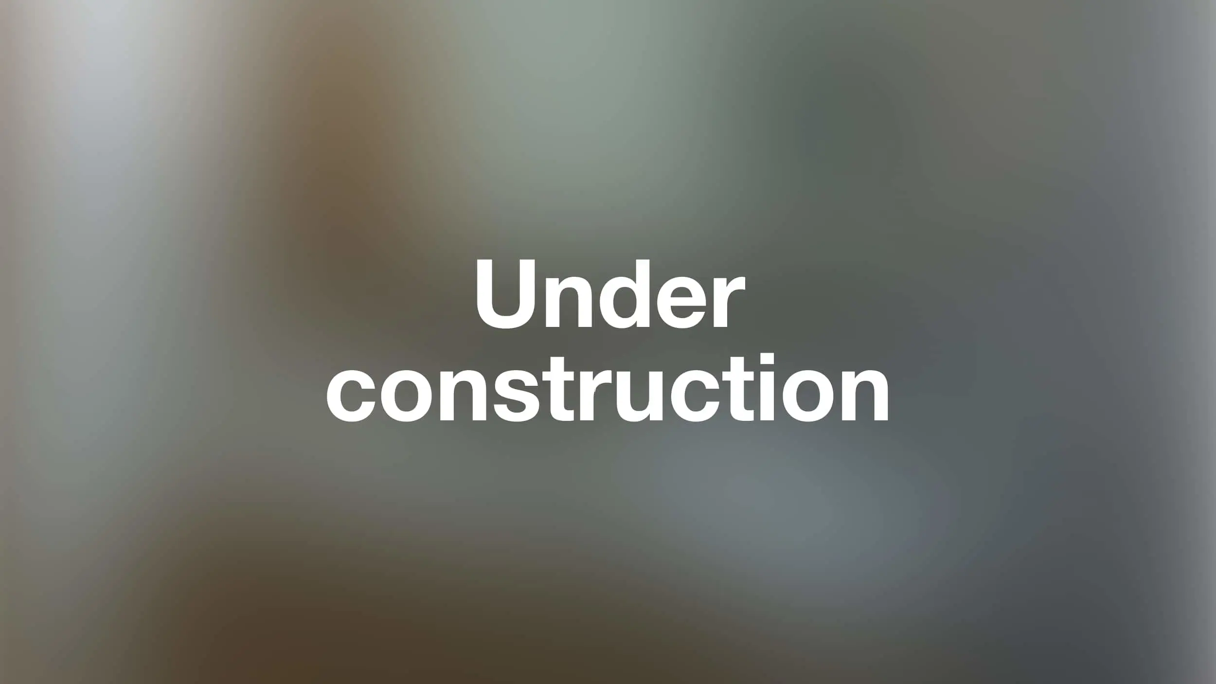 White bold text reading "Under construction" centered on a blurred gray and brown background.