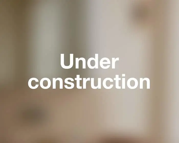 Blurred beige and grey background with white bold text reading "Under construction" in the center.
