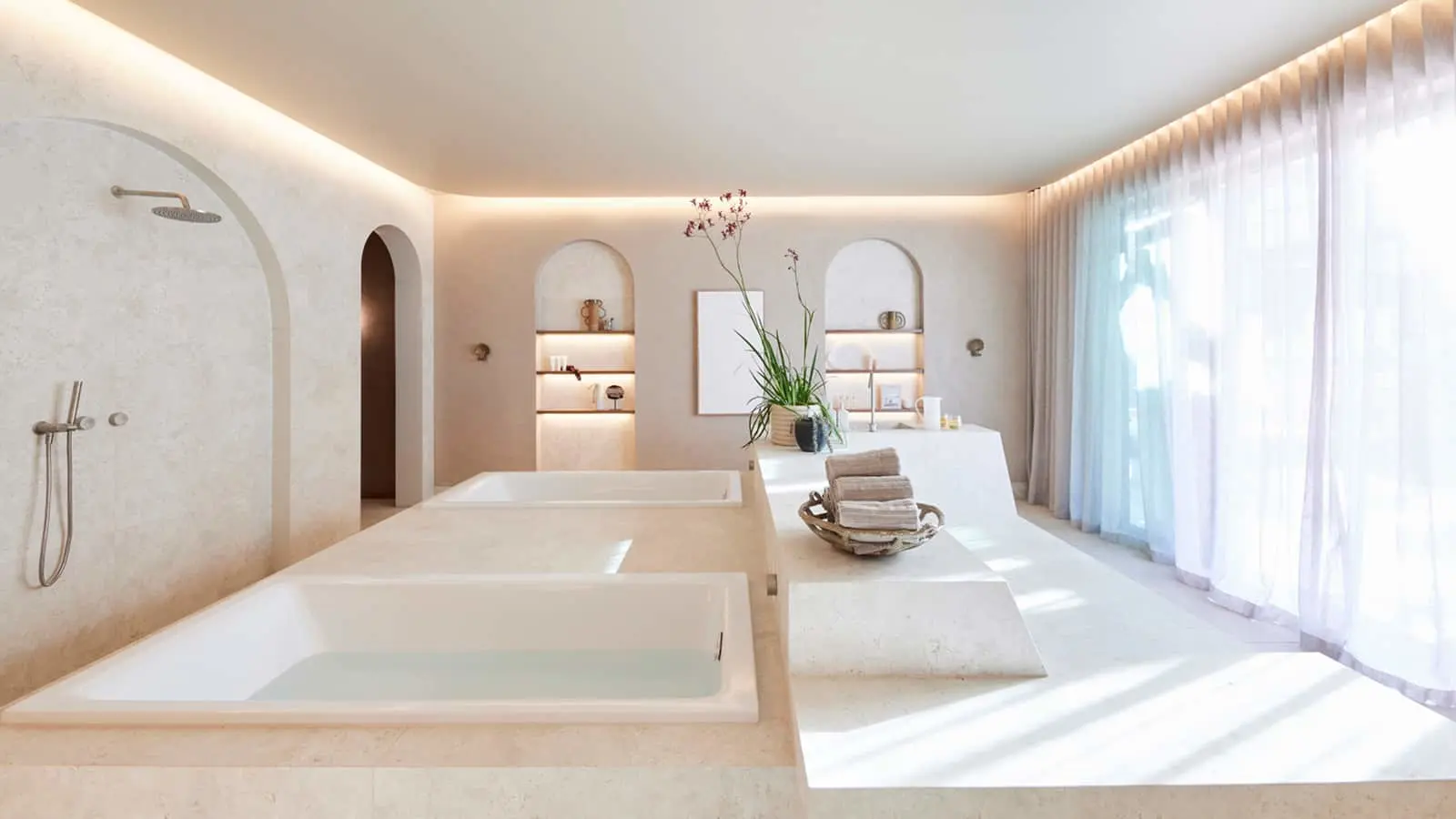 Modern spa bathroom with sunken bathtub, cream walls, arched niches, and soft lighting from ceiling and windows.