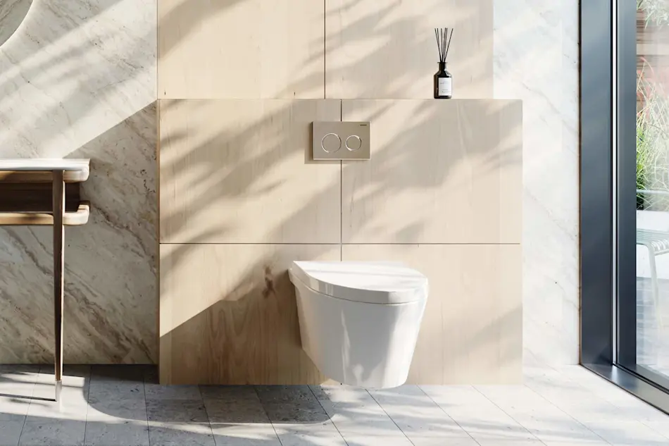 Modern bathroom with wall-mounted white toilet, light wood paneling, marble accents, and reed diffuser on shelf.