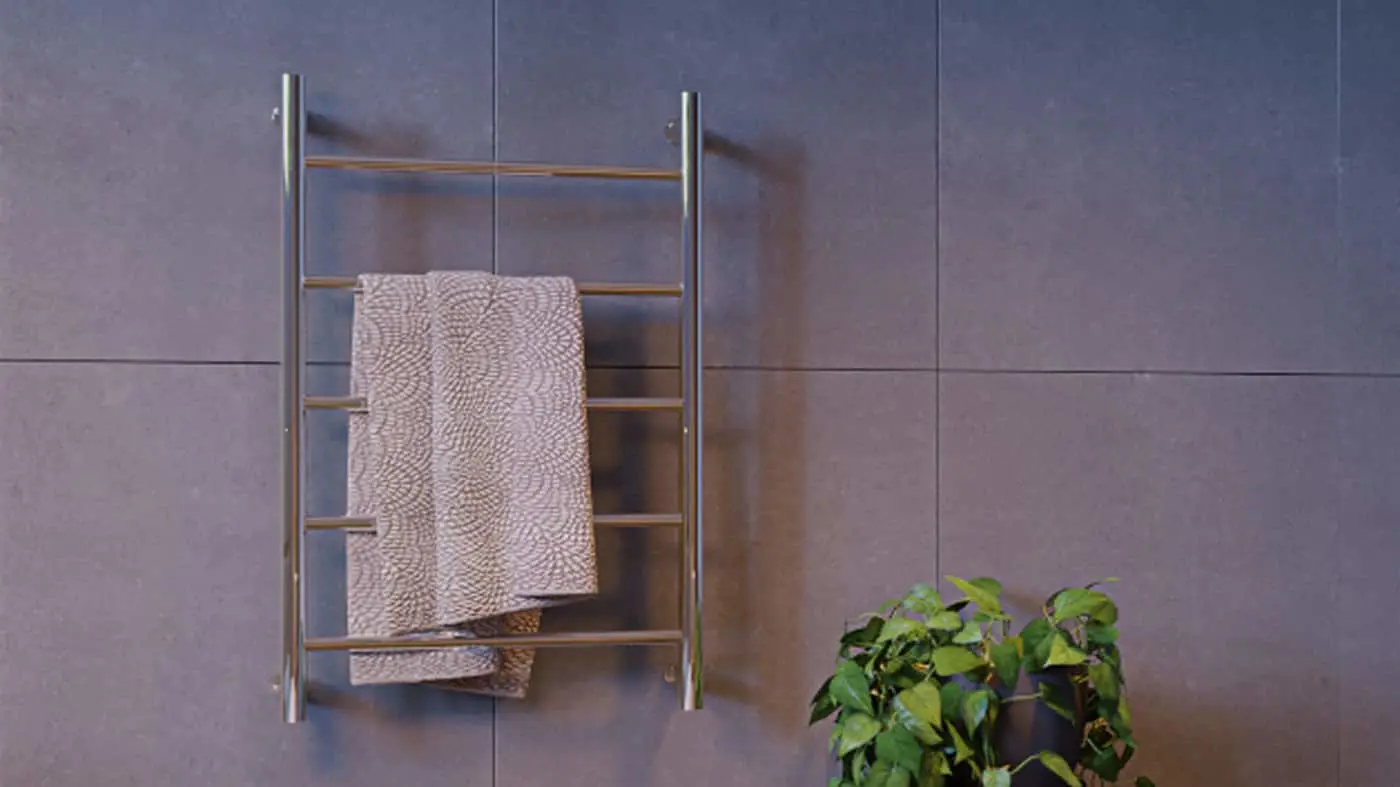Modern stainless steel towel rack with patterned beige towel mounted on gray tiled wall, small green plant in corner.