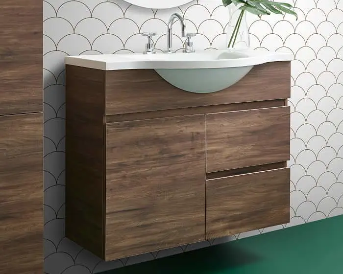 Modern bathroom vanity with dark wood cabinet, white sink, and chrome faucet against scalloped pattern wall tile.