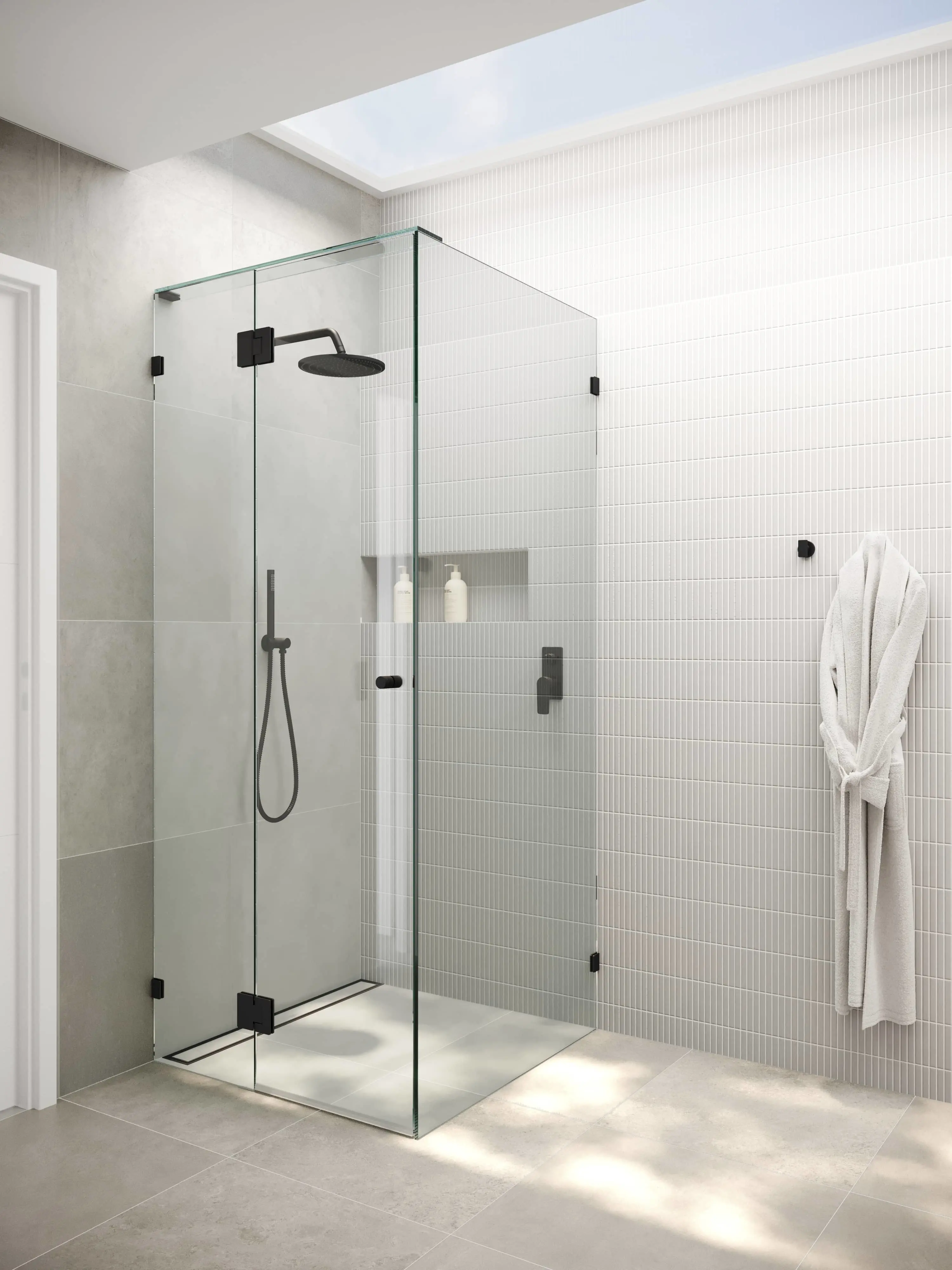 Modern bathroom with glass shower enclosure, white tiled walls, black fixtures, and a white bathrobe hanging nearby.