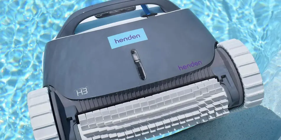 Gray Henden H3 robotic pool cleaner with white wheels floating in blue swimming pool water.