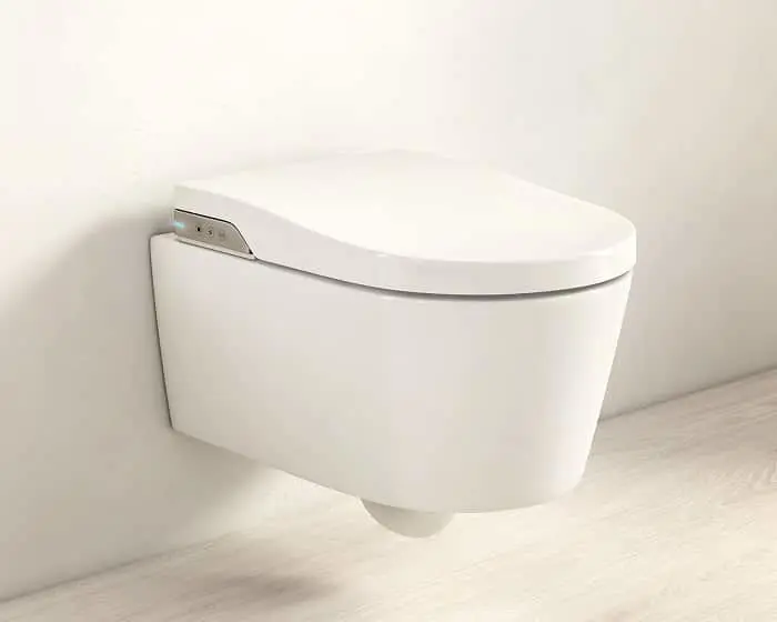 Modern white wall-mounted smart toilet with electronic bidet seat against a light-colored wall and floor.