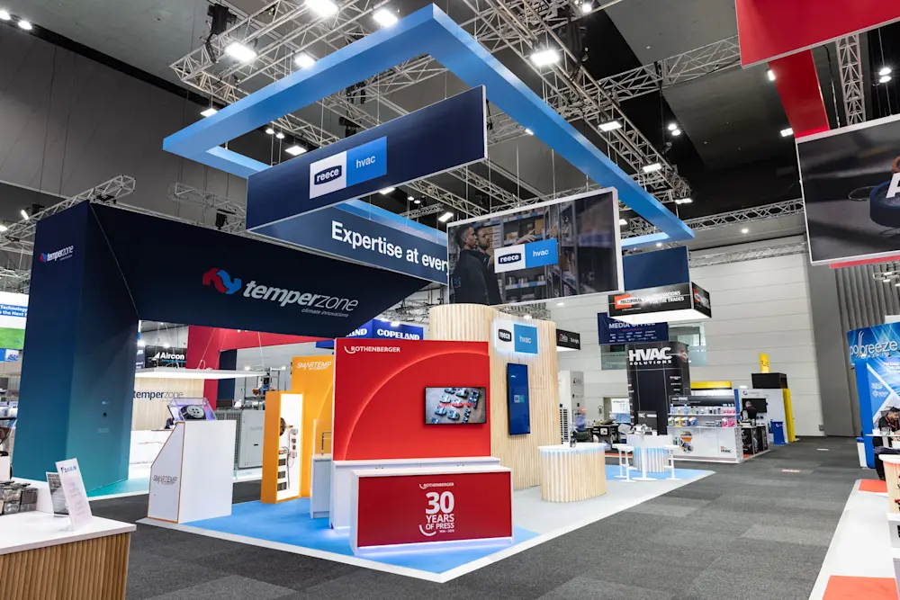 Trade show floor with Reece HVAC and Temperzone exhibition booths featuring blue, red, and orange displays.