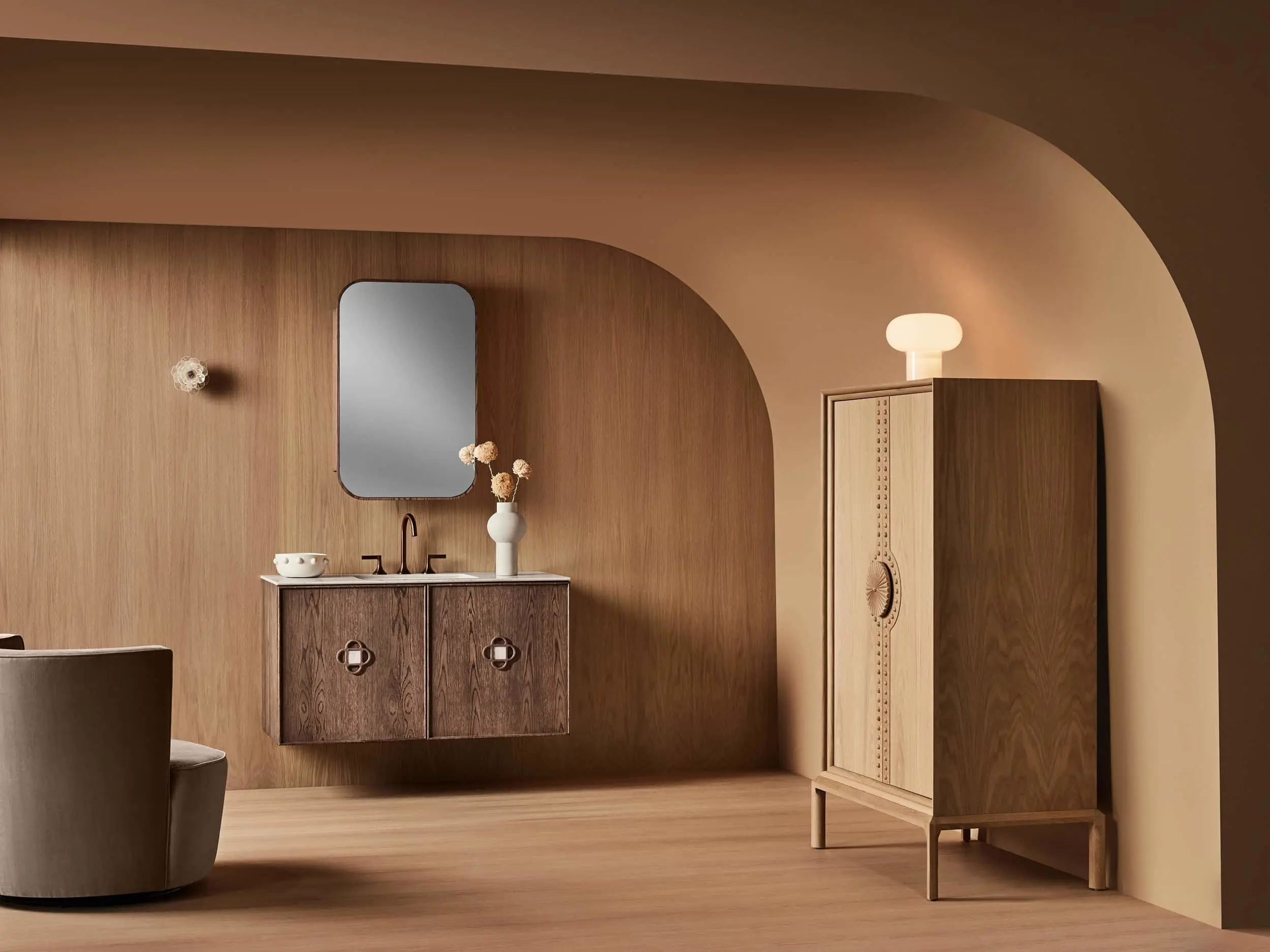 Modern bathroom with wooden vanity, rounded mirror, and wooden cabinet in a warm-toned curved archway interior.