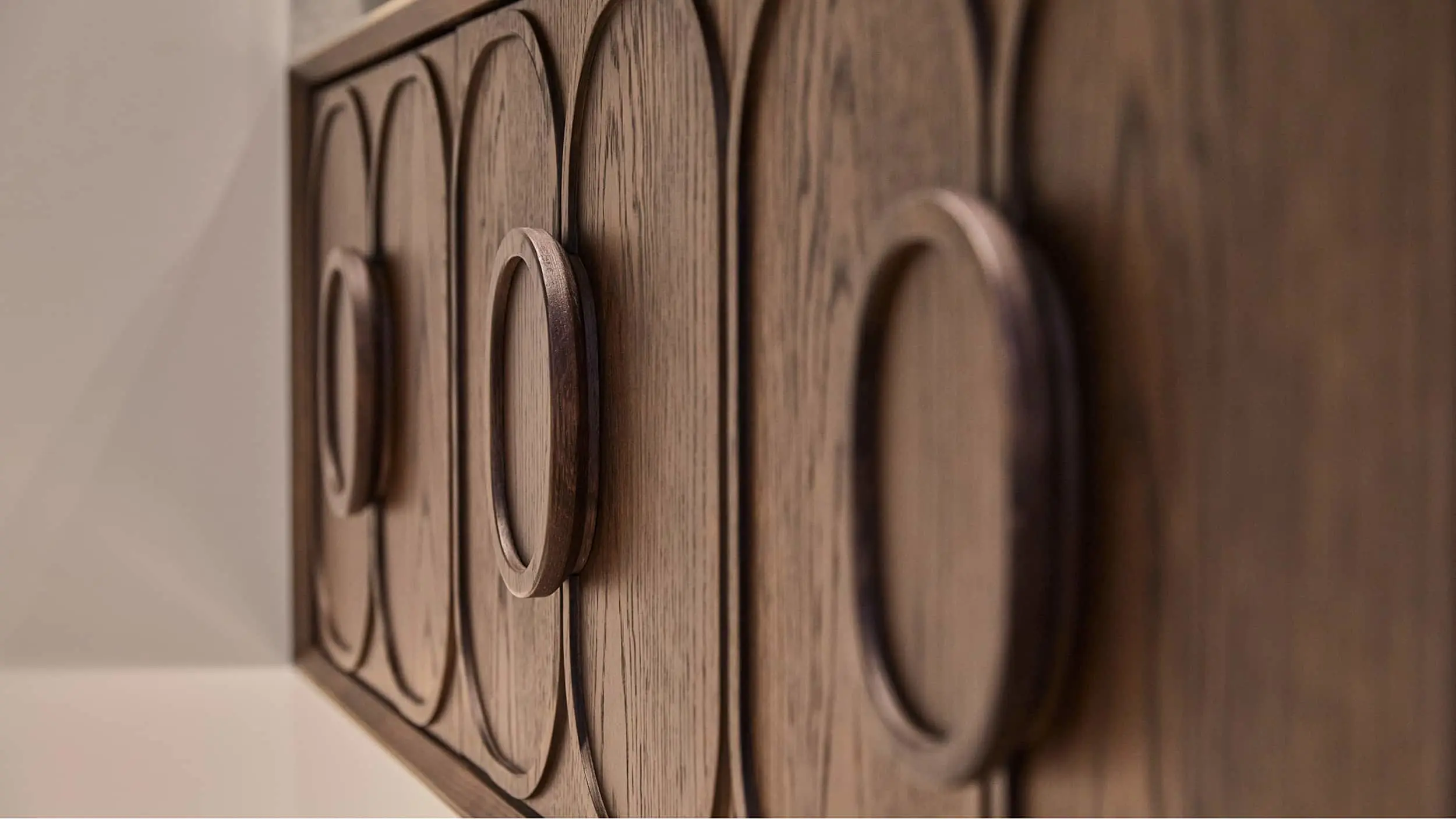 Close-up of wooden cabinet doors with circular decorative panels showing detailed grain texture and craftsmanship.