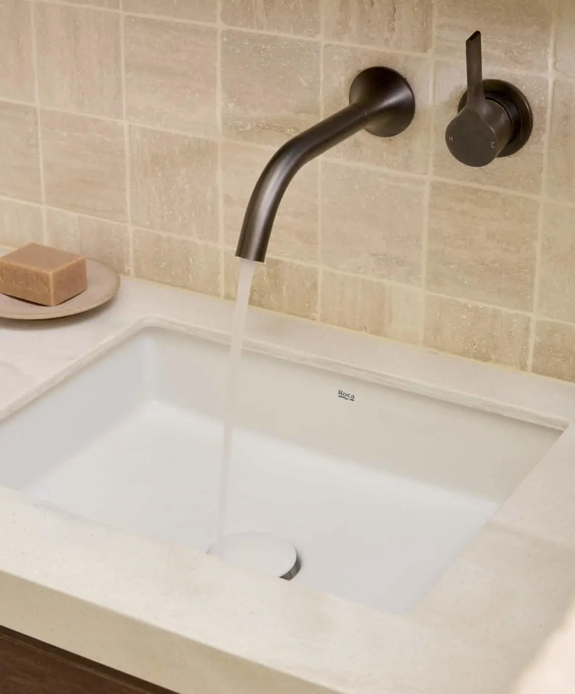 Modern bathroom featuring a white sink with gunmetal wall-mounted faucet.