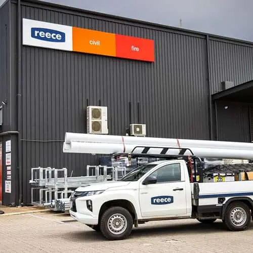 White Reece company truck parked outside a gray industrial building with Reece, civil, and fire signage.