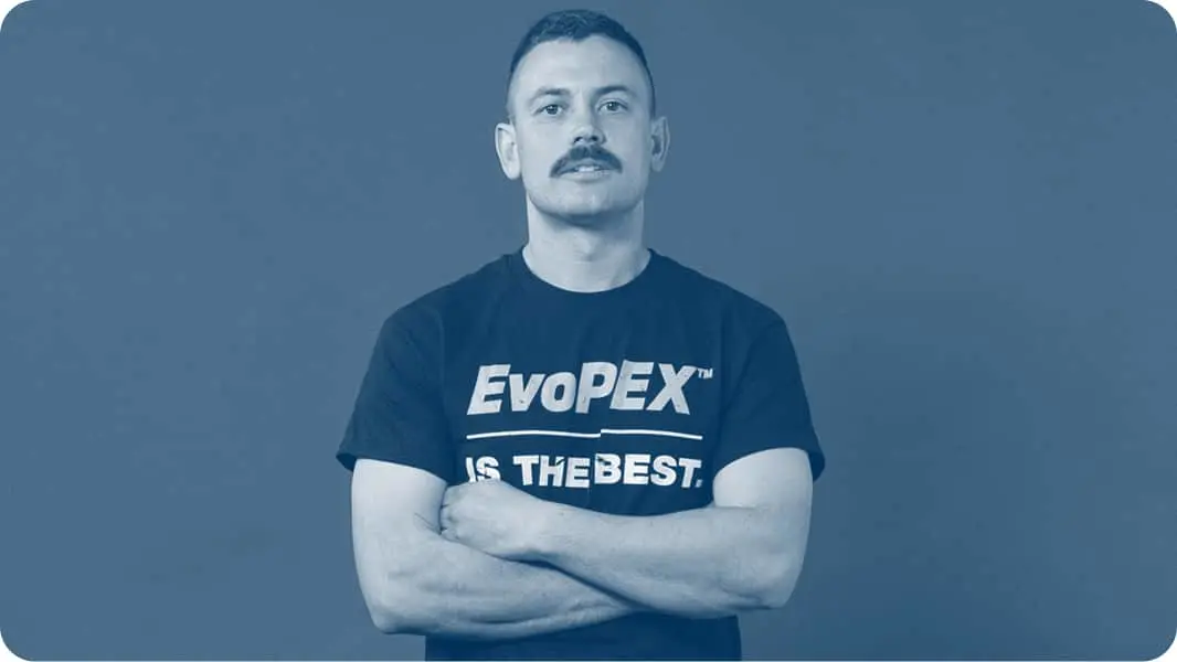 Person with mustache wearing dark t-shirt with "EvoPEX IS THE BEST" text, standing with arms crossed against blue background.