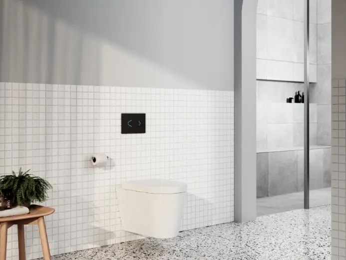 Modern bathroom with white tiled walls, wall-mounted toilet, terrazzo floor, and small wooden stool with plant.