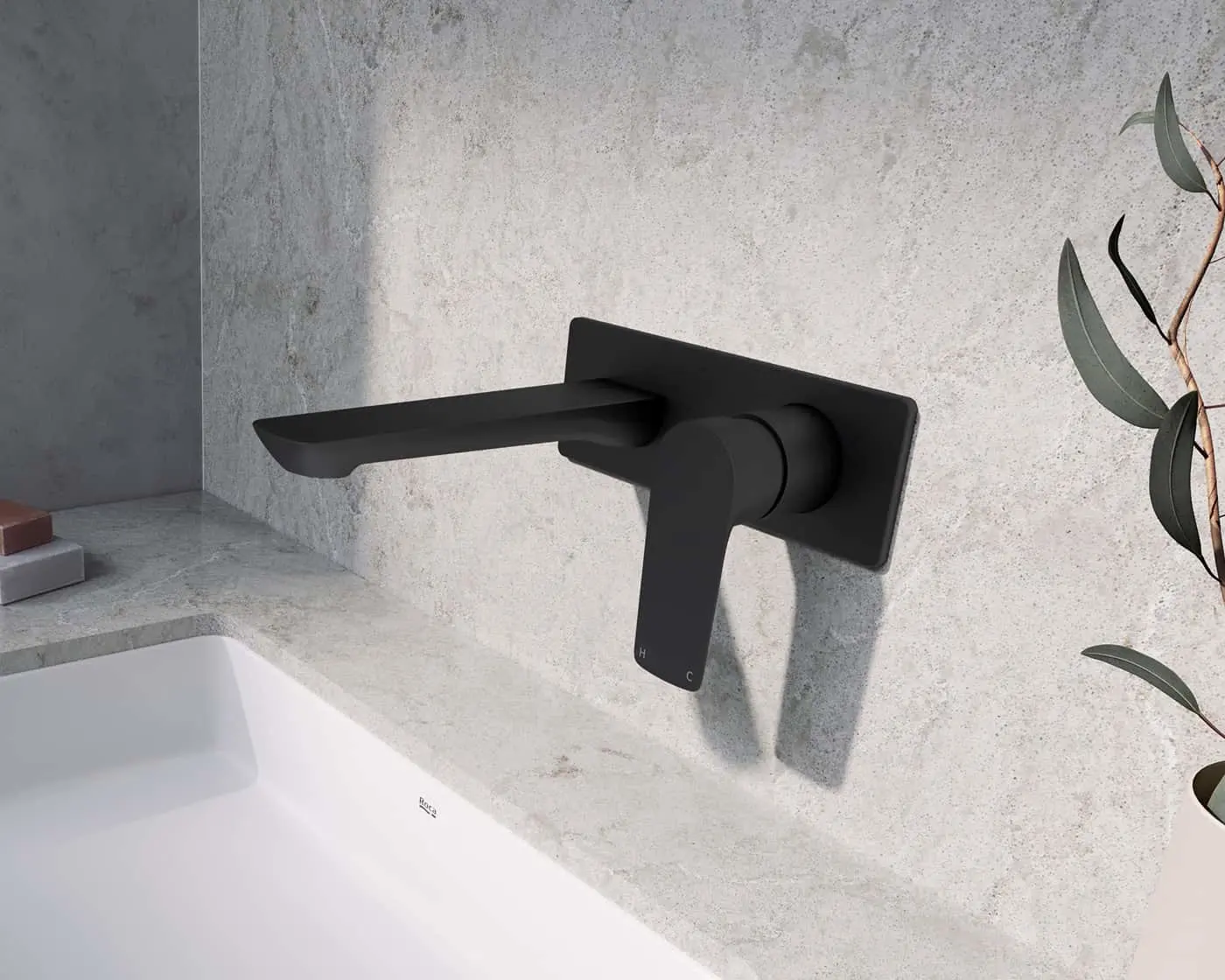 Modern black wall-mounted bathroom faucet with flat spout against light gray concrete wall, eucalyptus branch visible.